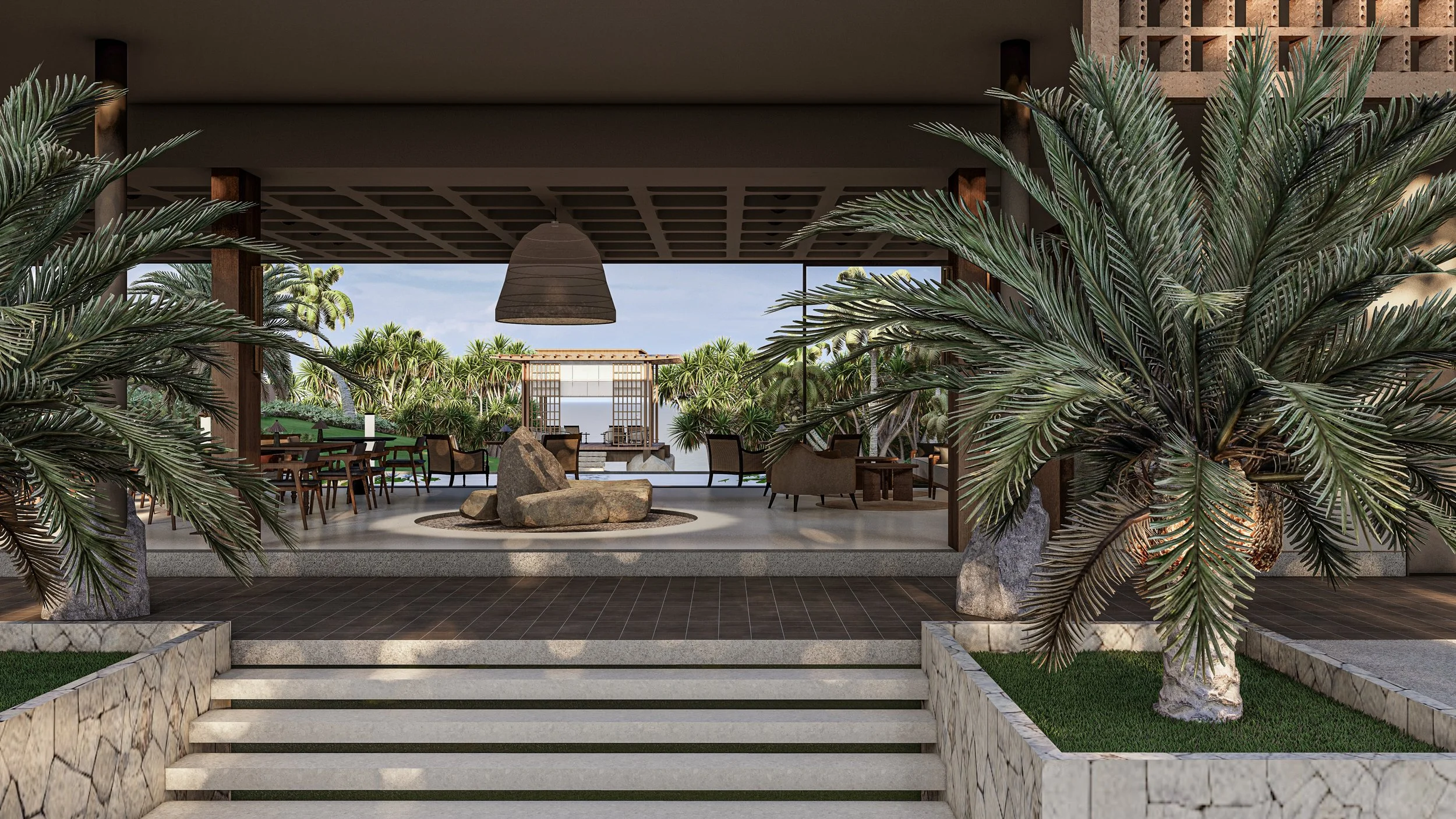 A modern outdoor patio with tropical plants, wooden furniture, a large hanging lamp, and a view of lush green trees and a small structure in the background.