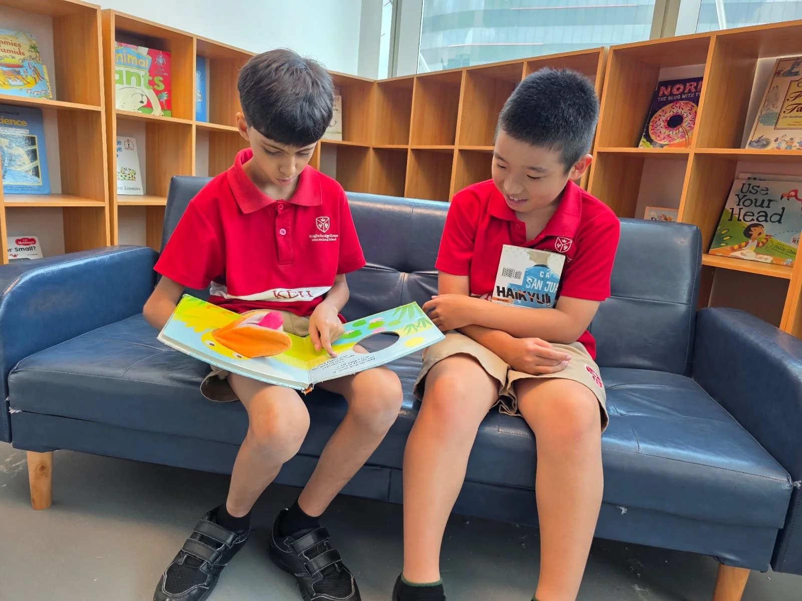 knightsbridge house international students reading and sharing a book in the library