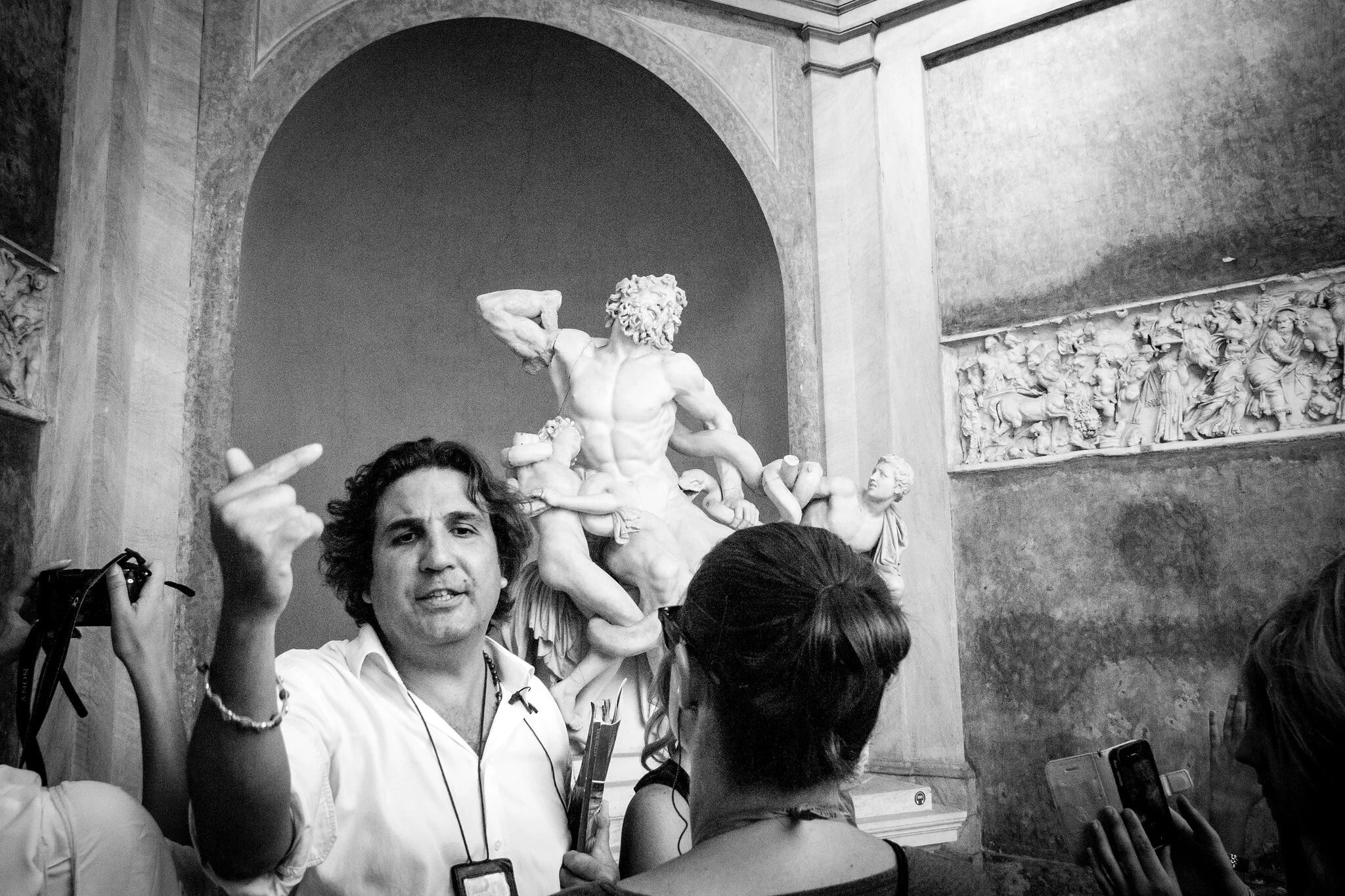 Vatican visitors taking pictures in front of  sculpture.