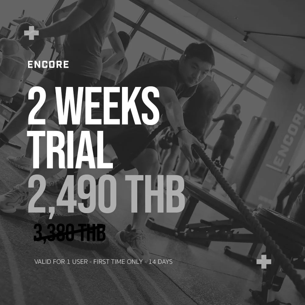 A group fitness class in a gym with people exercising, featuring a man pulling a battle rope. Overlaid text advertises a two-week trial offer for 2,490 THB, reduced from 3,380 THB, valid for one user, for the first time only, for 14 days.