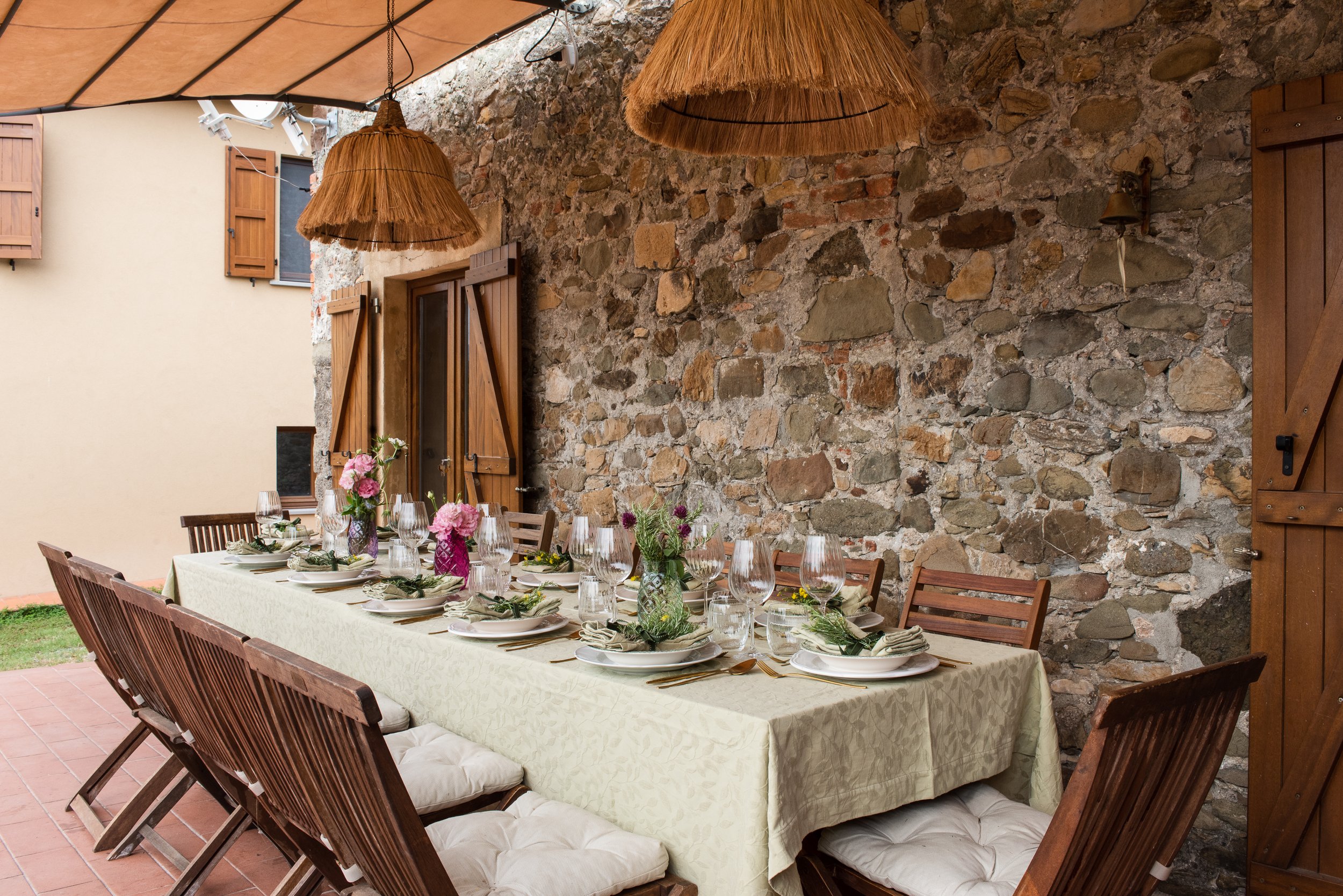 Outdoor dining table under the veranda at I Ginepri Country House in Tuscany