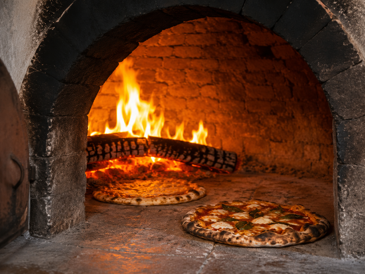 Pizzas cooking in the wood-fired oven at I Ginepri Country House in Tuscany
