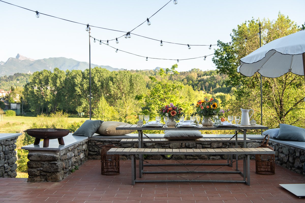 Outdoor dining area at I Ginepri Country House overlooking the Apuan Alps in Tuscany
