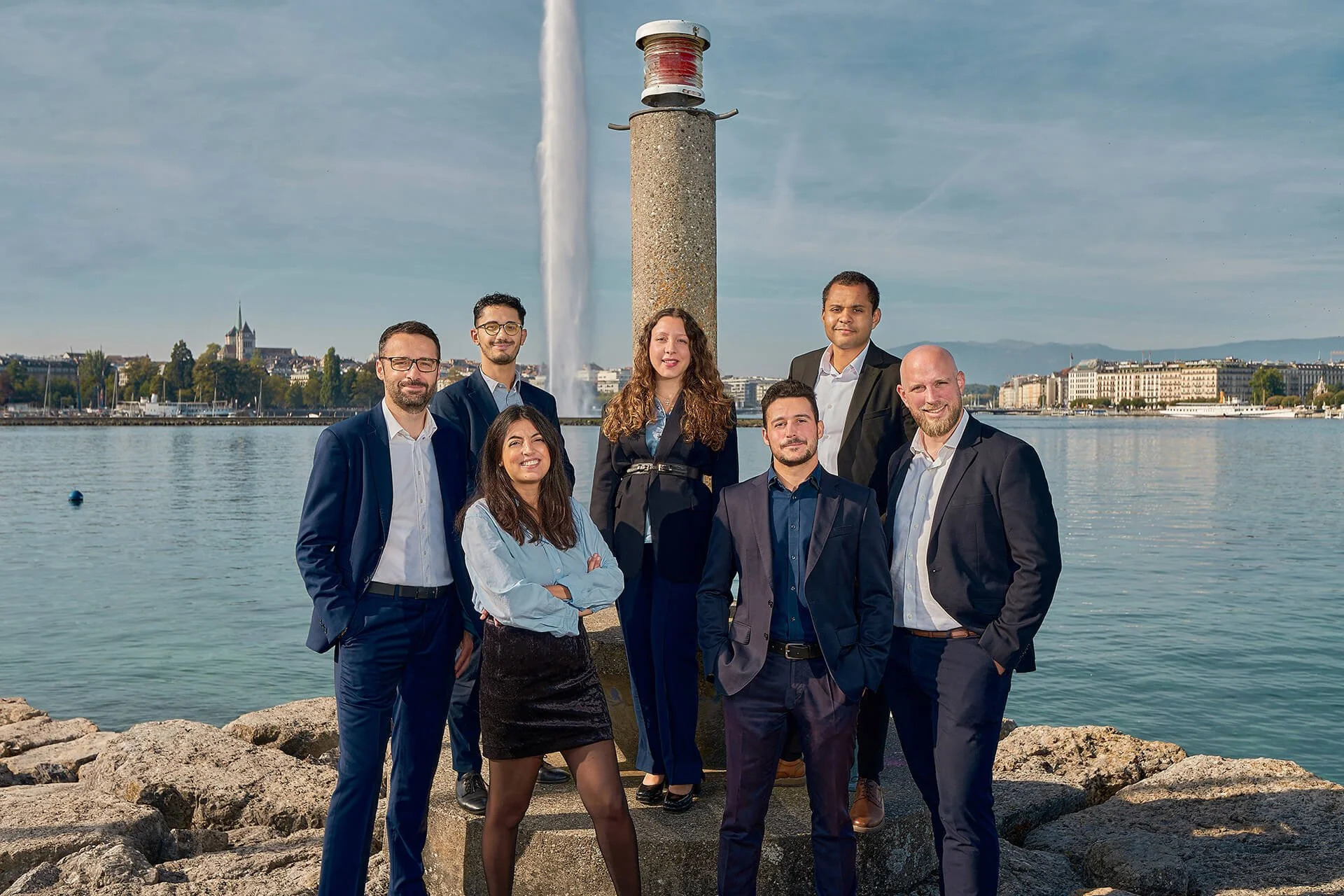 Portrait by Patric Pop, top corporate photographer in Geneva of the newly promoted team members at Berney Associés, posing with the skyline of Geneva in the background.