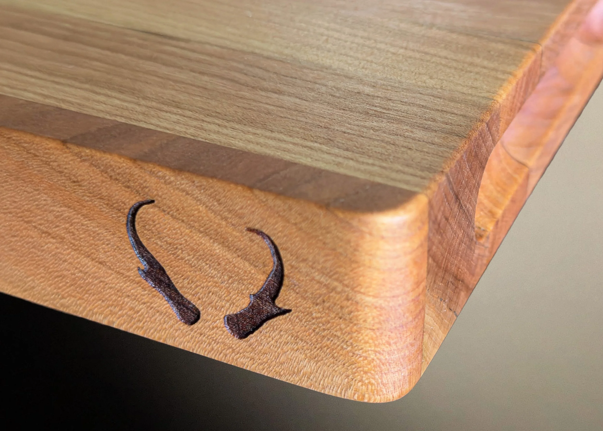 Close-up of a wooden cutting board with pronghorn horns laser etched on the side.