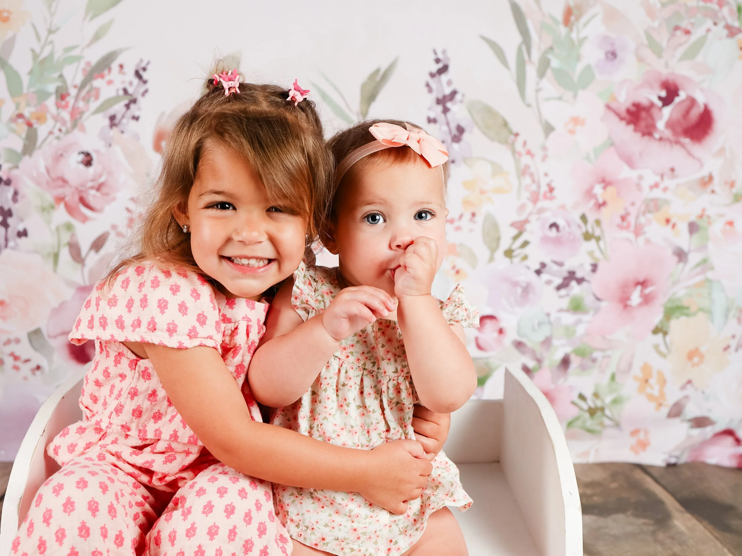 two sisters wearing pink hugging for school photo day
