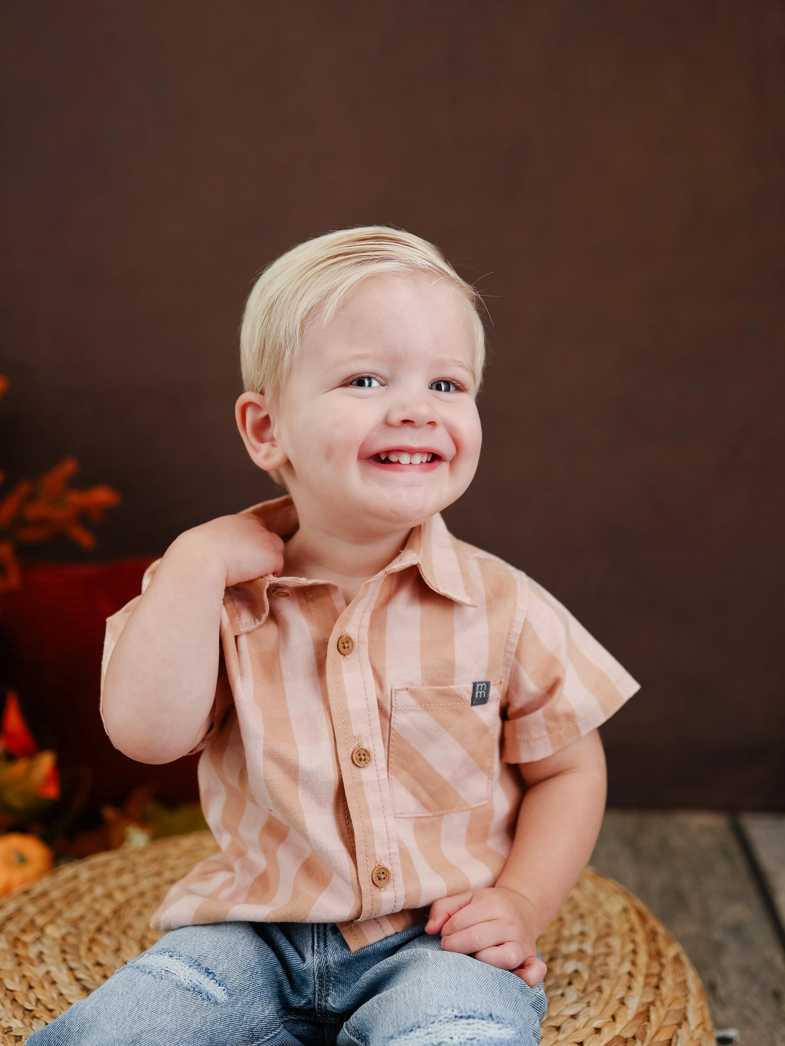 Preschool boy sitting for fall portrait with pink and beige collard shirt on