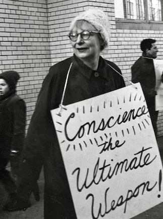 JANE JACOBS URBAN ACTIVIST HISTORIAN AND PRESERVATIONIST HOLDING SIGN READING CONSCIENCE THE ULTIMATE WEAPON