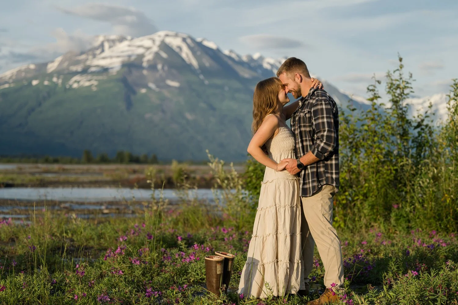 Portrait of a couple interracting for a portrait with the mountains and fireweed around. 