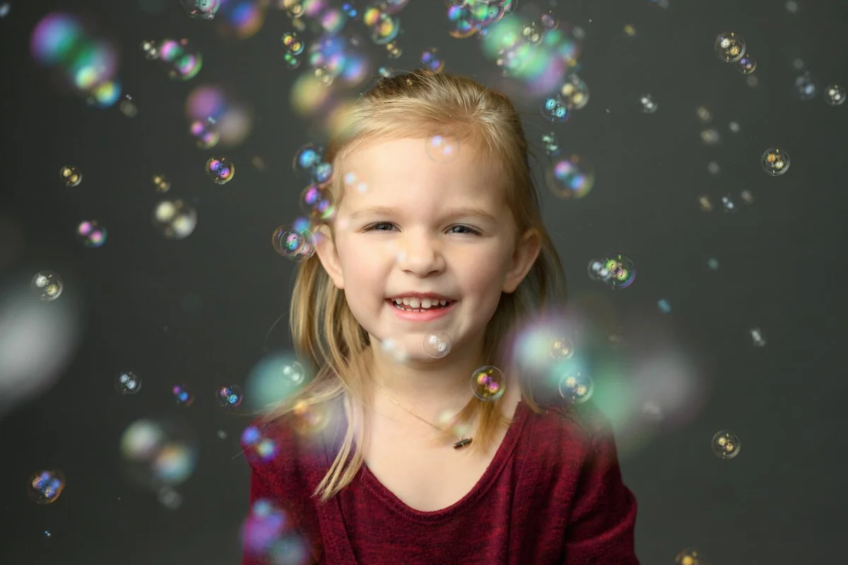 Portrait of little girls with bubbles around