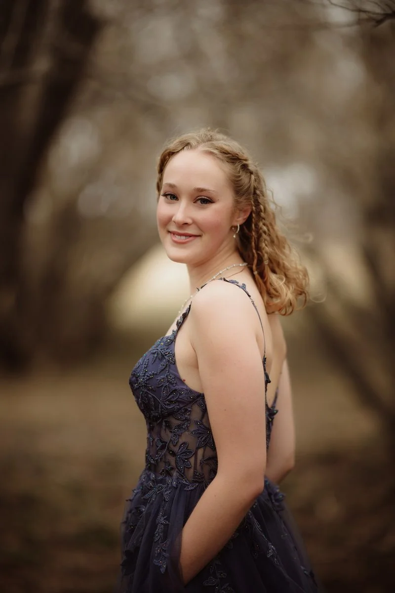 Beautiful portrait of girl with blond hair against lilac bushes for prom photos