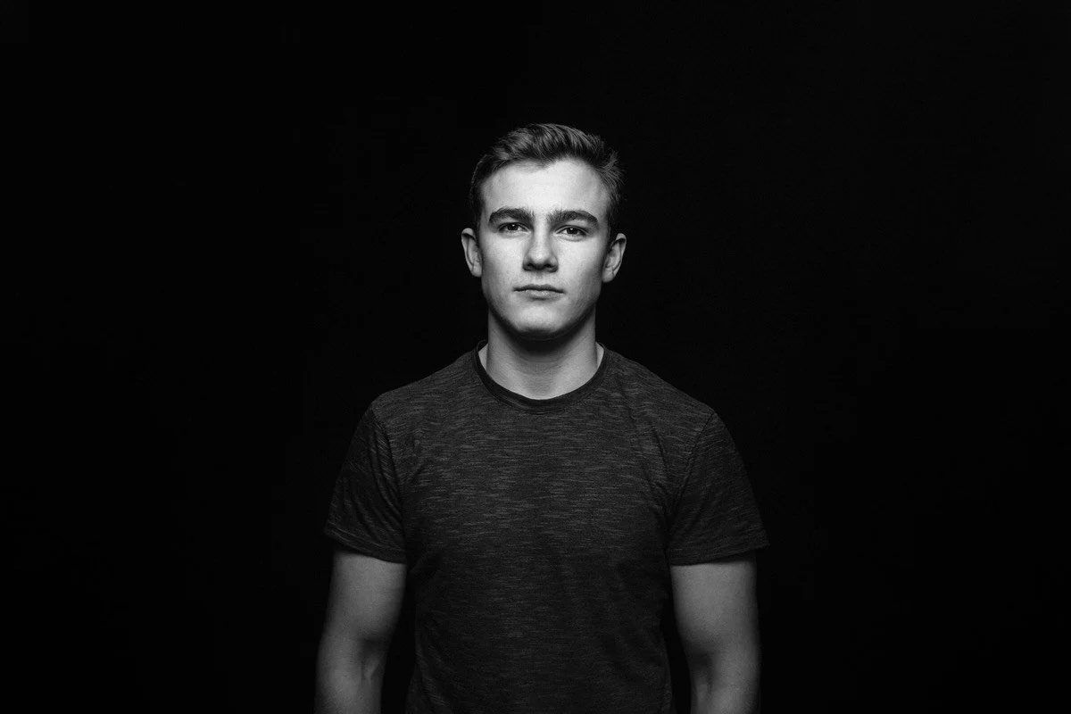 Black and white high school senior portraits  on a black background in windswept studio.