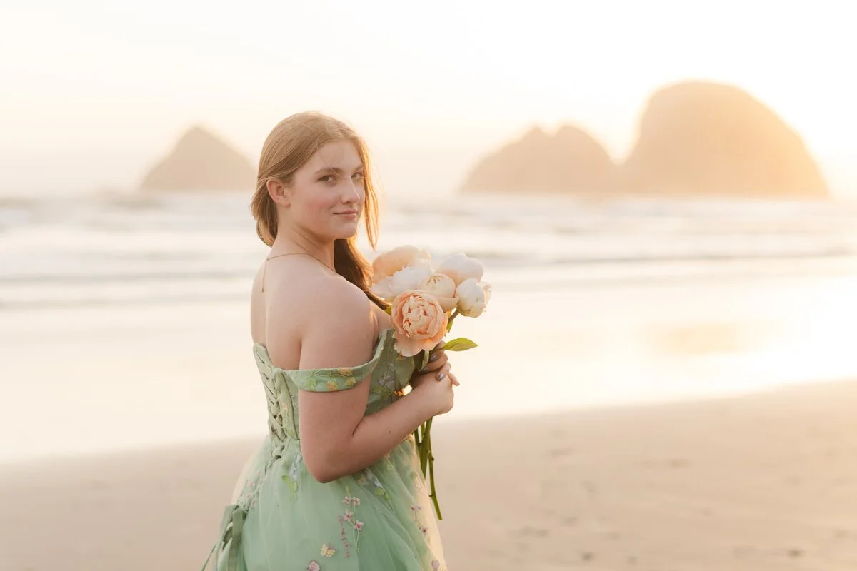 Portrait of beautiful girl wearing a green thrifted dress and holding a boquet of peonies along the oregon coast