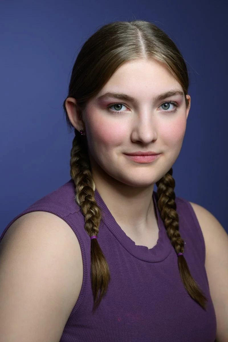 Portrait of a girl wearing purple and a purple background for a headshot