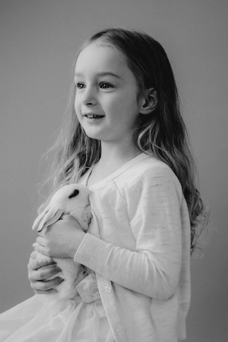 Black and white photo of little girl with a blance de hotot rabbit