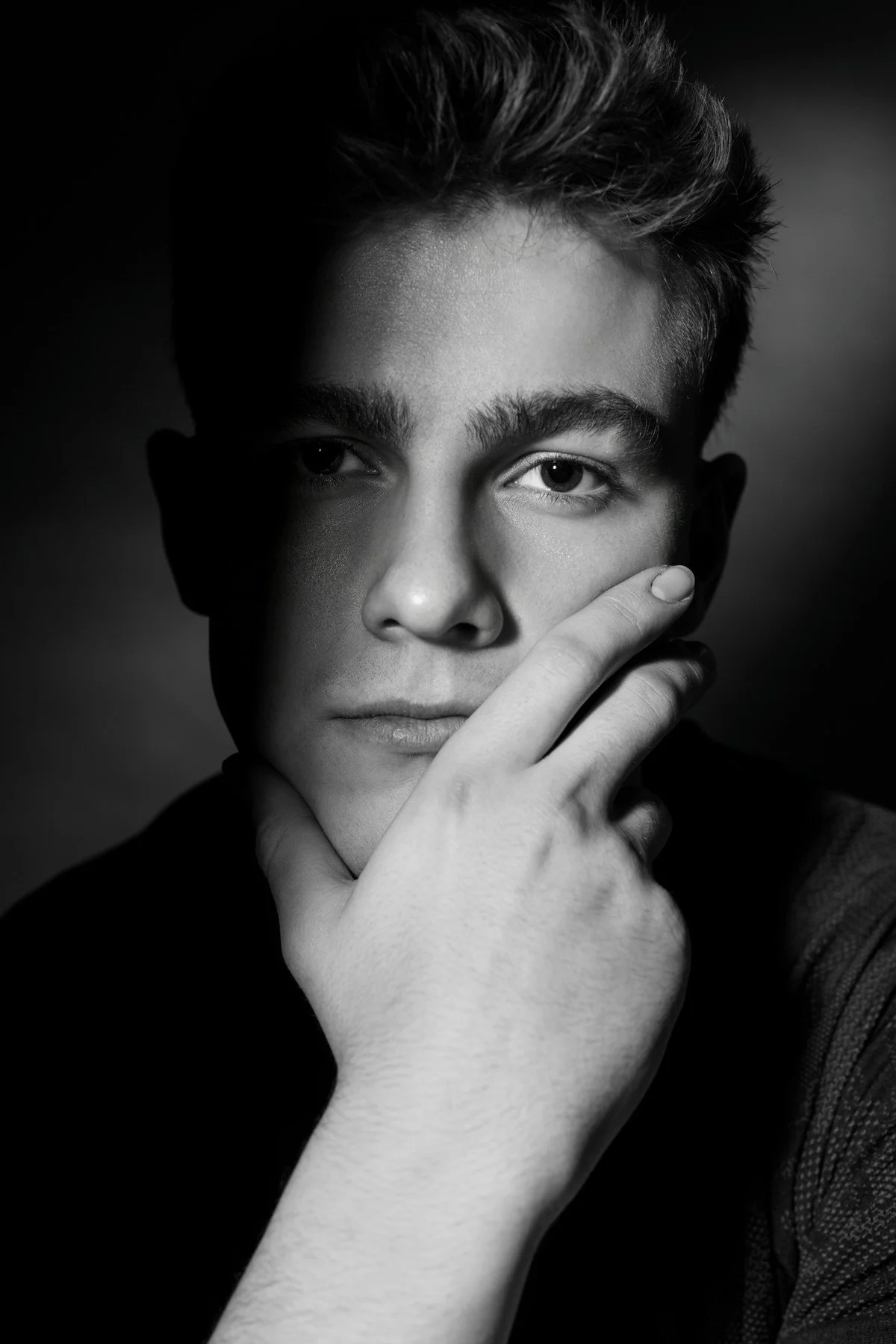 Black and white portrait of a man holding his face with his hand