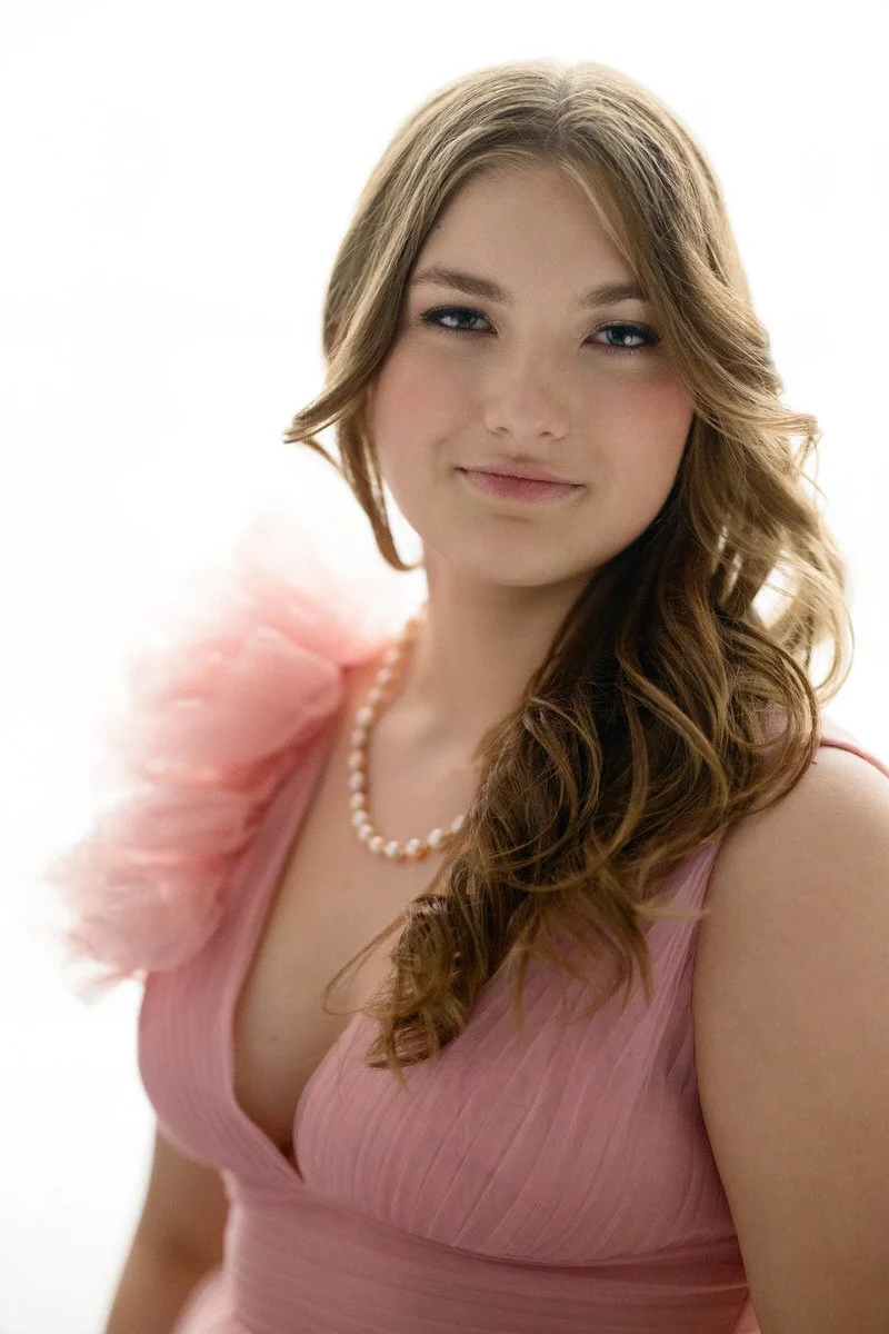 backlight image of a teenage girl posing in her prom gown