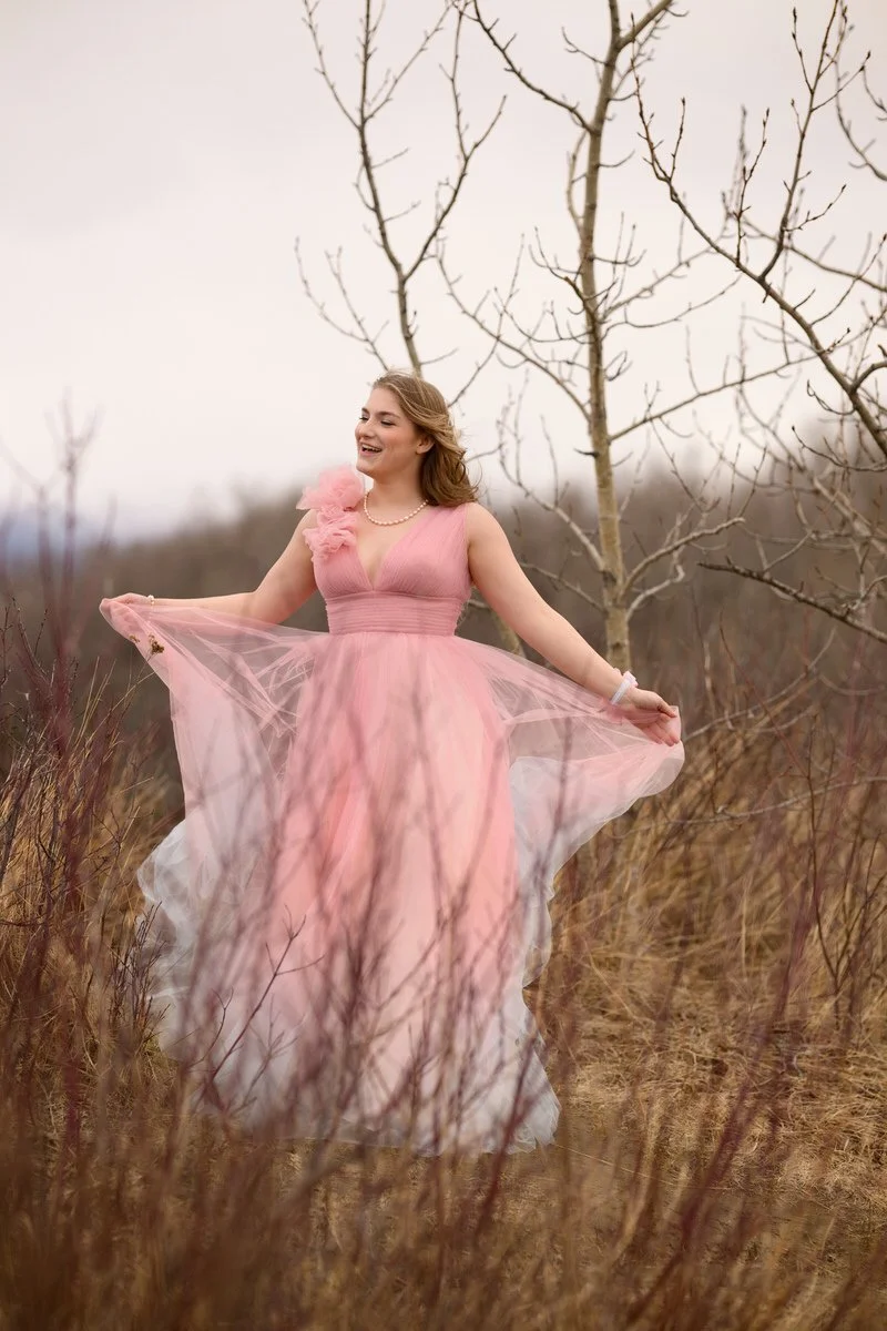 Girl wearing a pink gown, dances in her high school prom gown