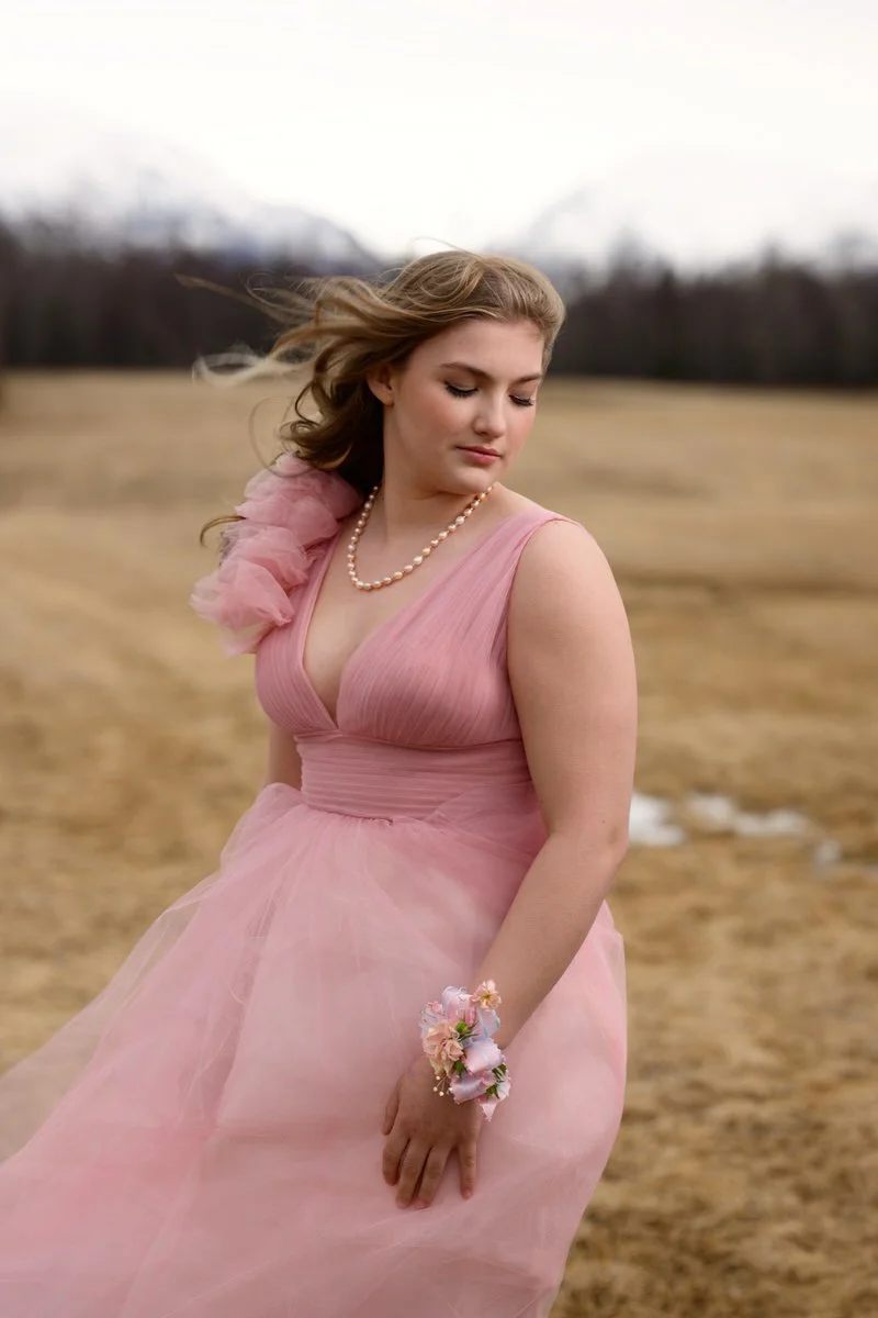 portrait of a beautiful senior girl in her pink prom gown for a portrait session in palmer, alaska