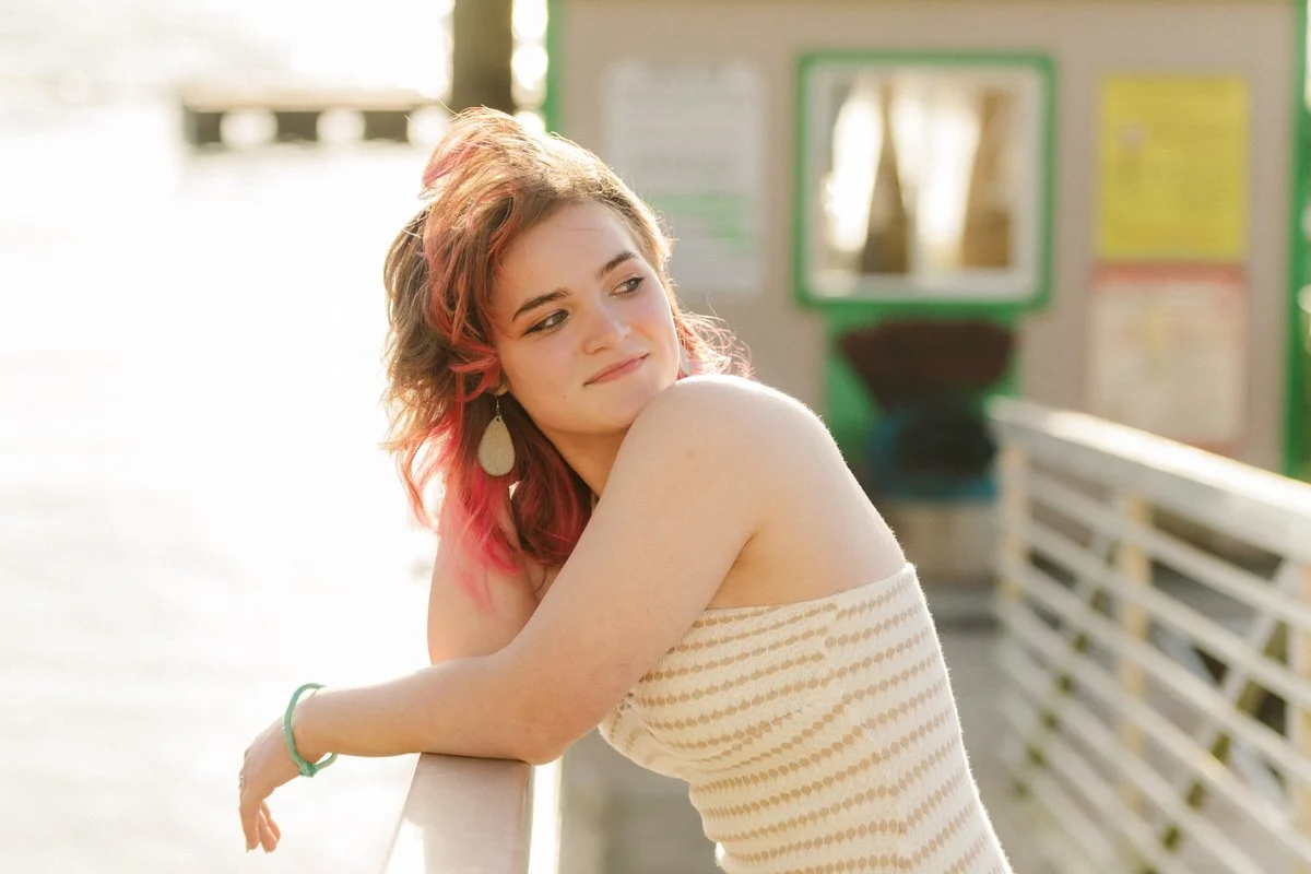 Portrait of a girl standing on a dock on the oregon coast for senior portraits