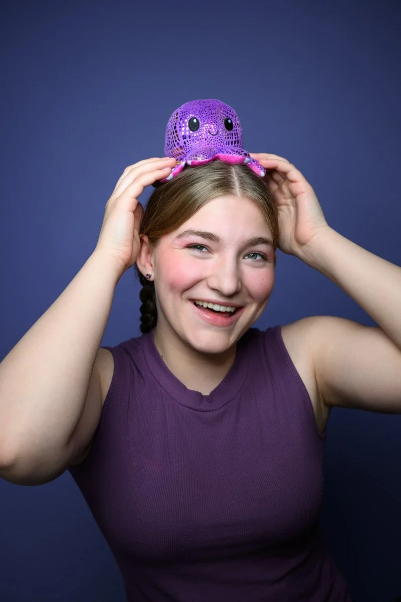 Headshot of girl wearing a toy octopus on her head for her heashot