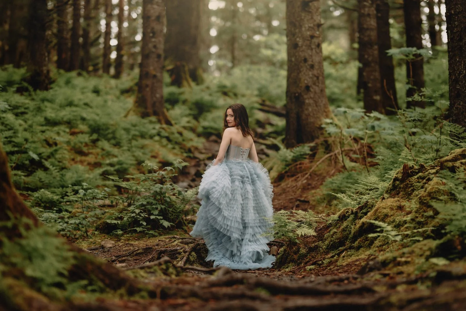Portrait of a girl in a prom dress with the rainforest around her in Seward Alaska