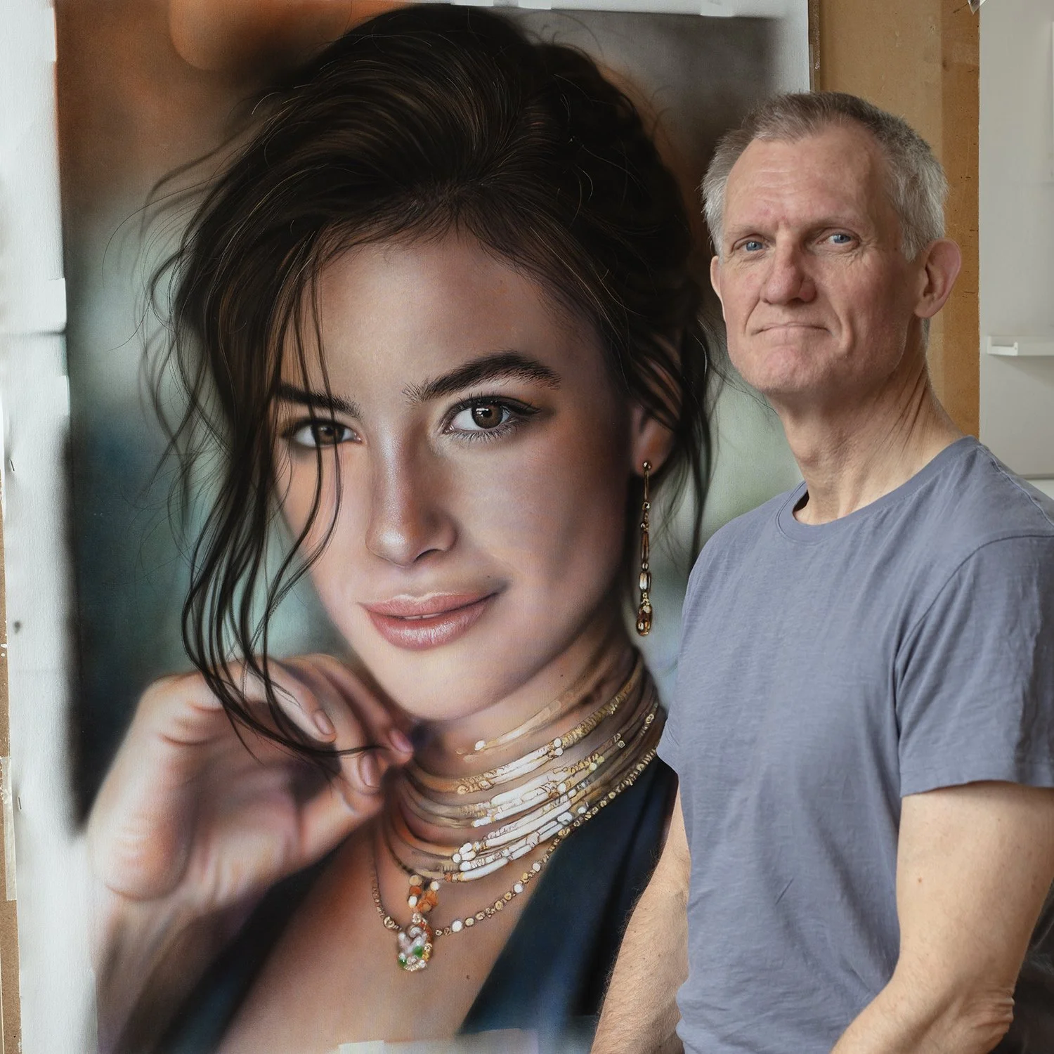 The artist Johannes Wessmark is standing next to his large painting of a woman wearing jewelry and smiling softly.