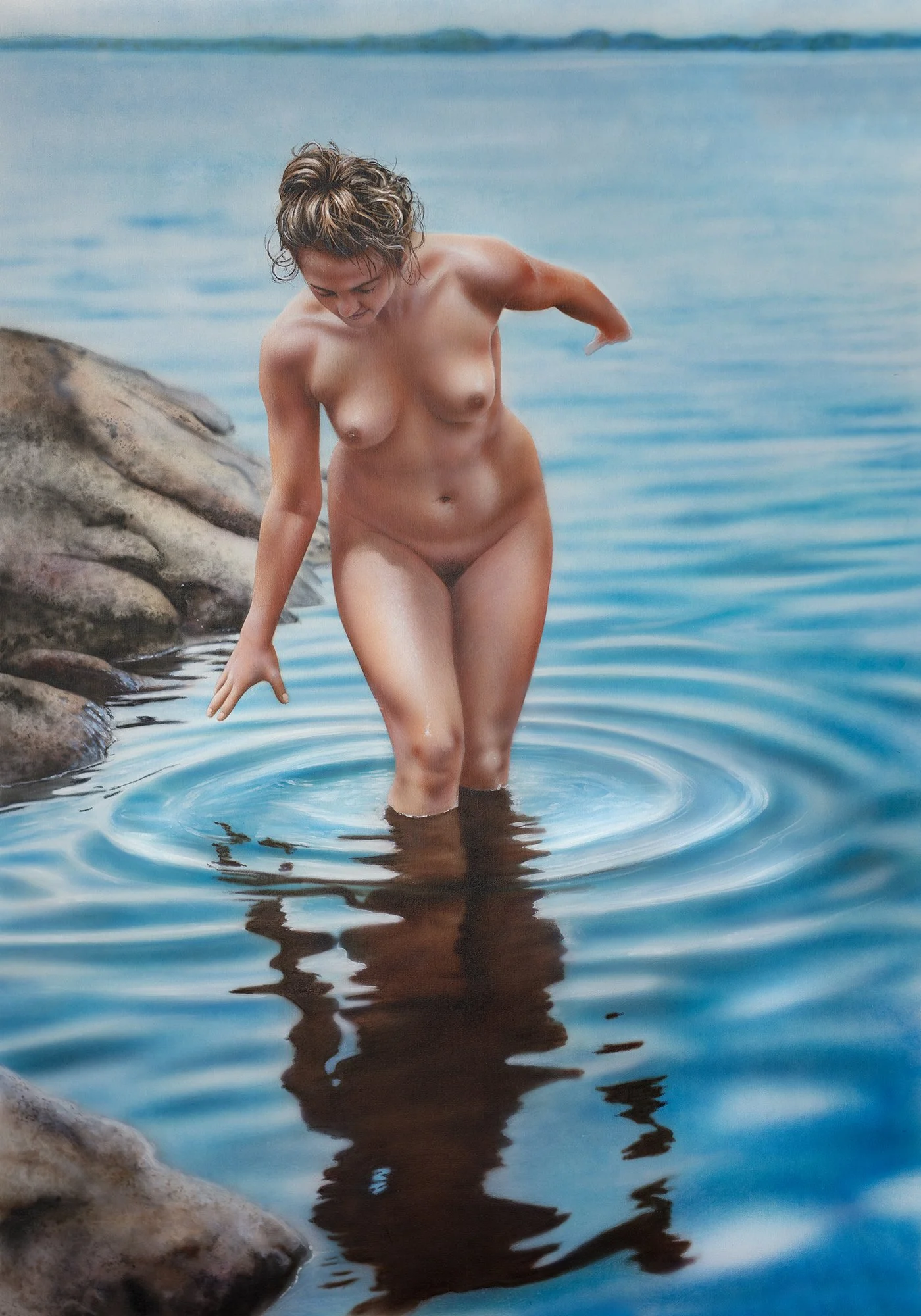 Vattenringar by Johannes Wessmark, a nude woman wading beside shoreline rocks with circular ripples and her reflection in blue water.