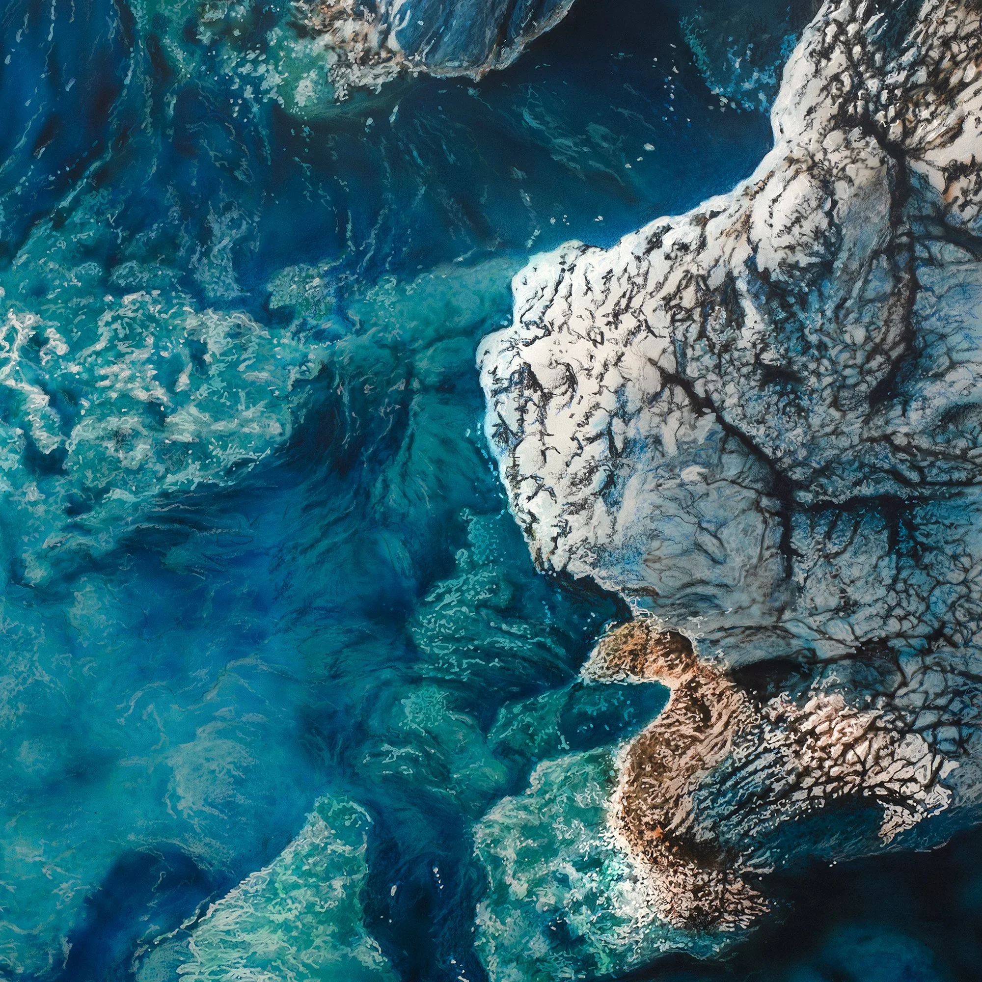The Reef by Johannes Wessmark, an overhead view of submerged rocks in clear turquoise and deep blue water beside pale shoreline stone.