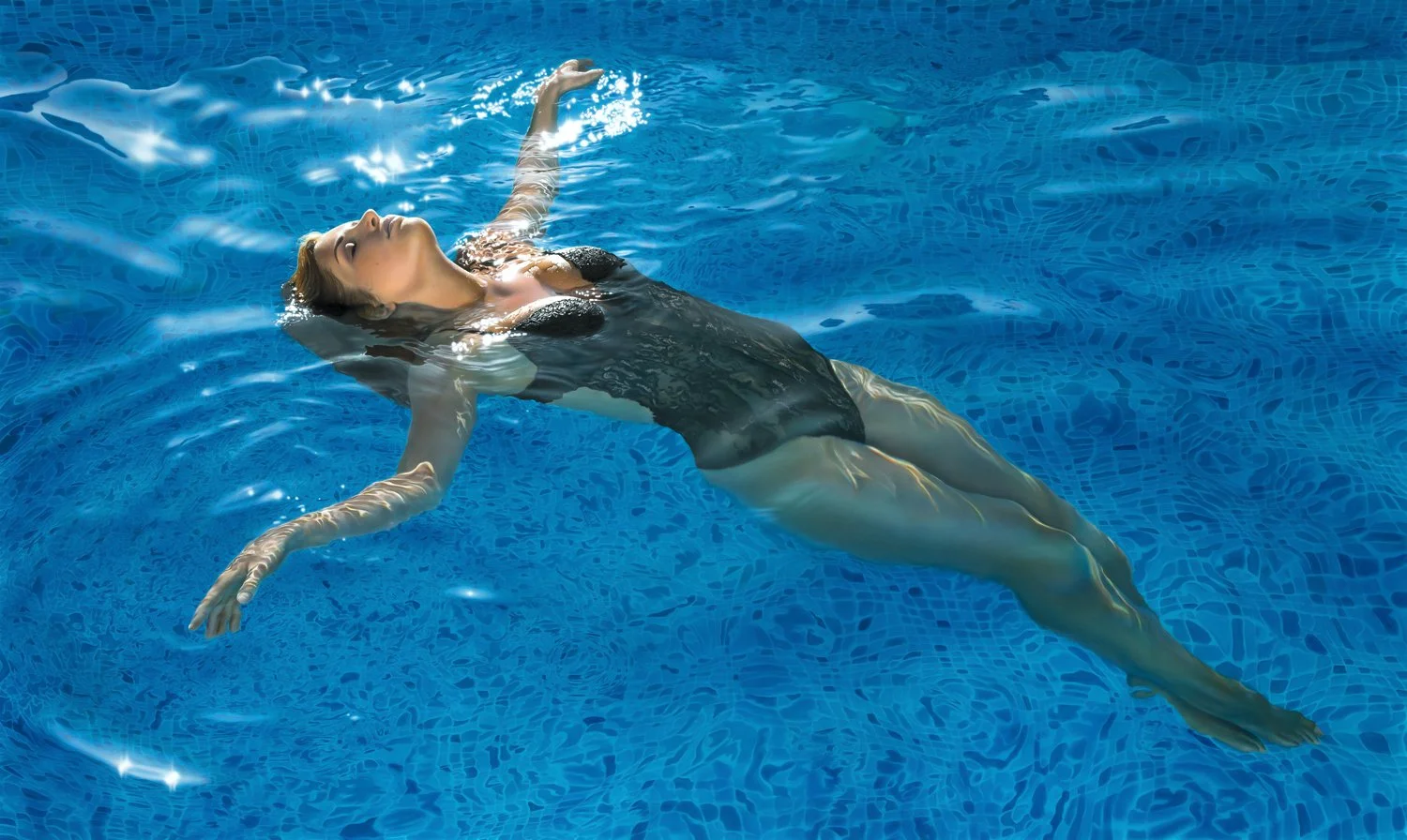 A woman in a black swimsuit floats on her back in a swimming pool with blue water.