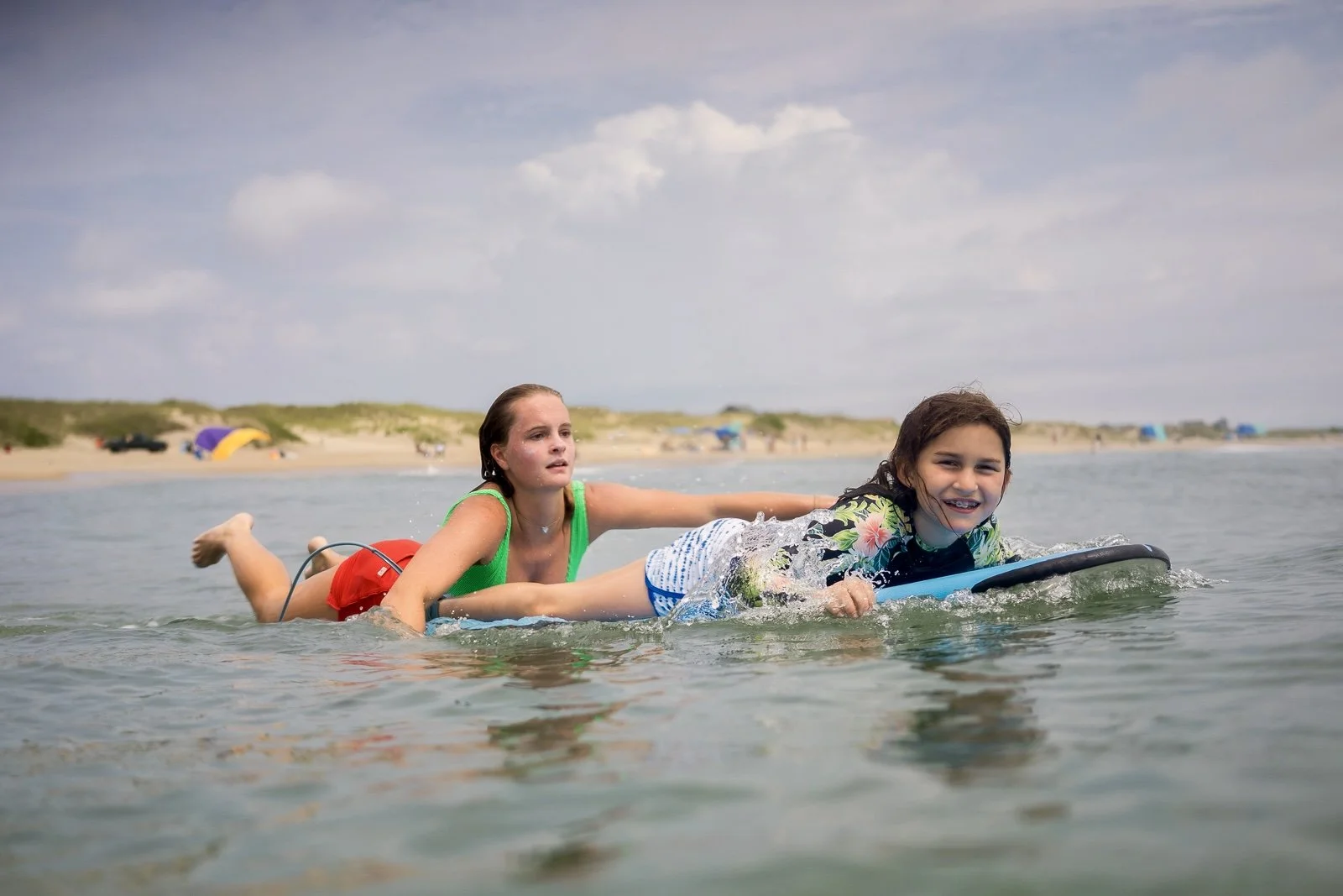 Female Surf Coach helping her student