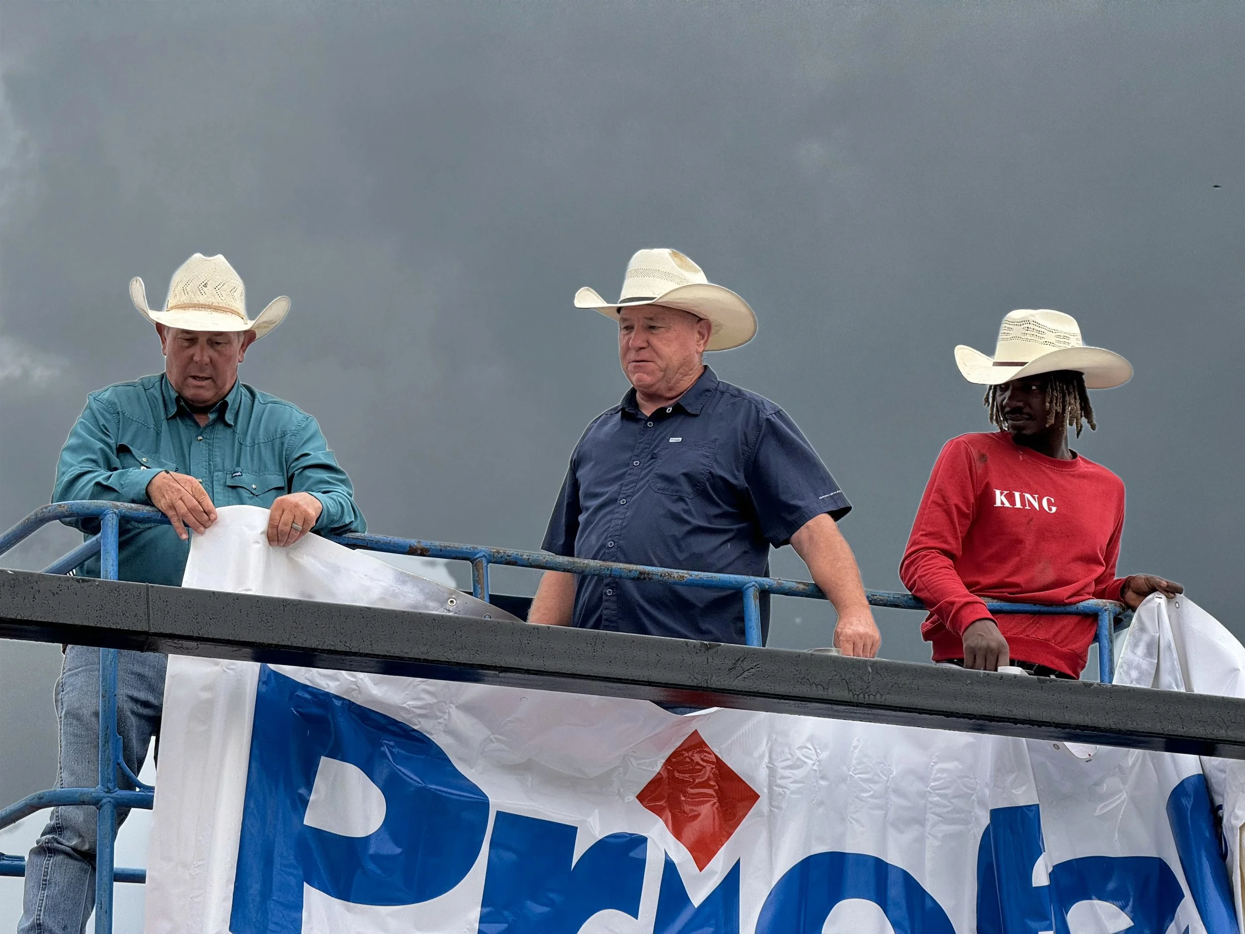 MPRA volunteers hanging a Priefert sponsor banner at the Mount Pleasant rodeo grounds