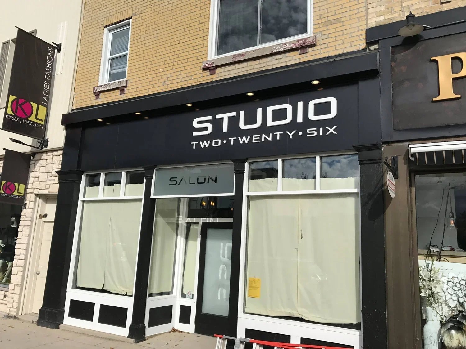 storefront with black signage reading 'STUDIO TWO TWENTY SIX' above large windows, with a sign that says 'SALON' inside - Signupsigns - Neustadt.
