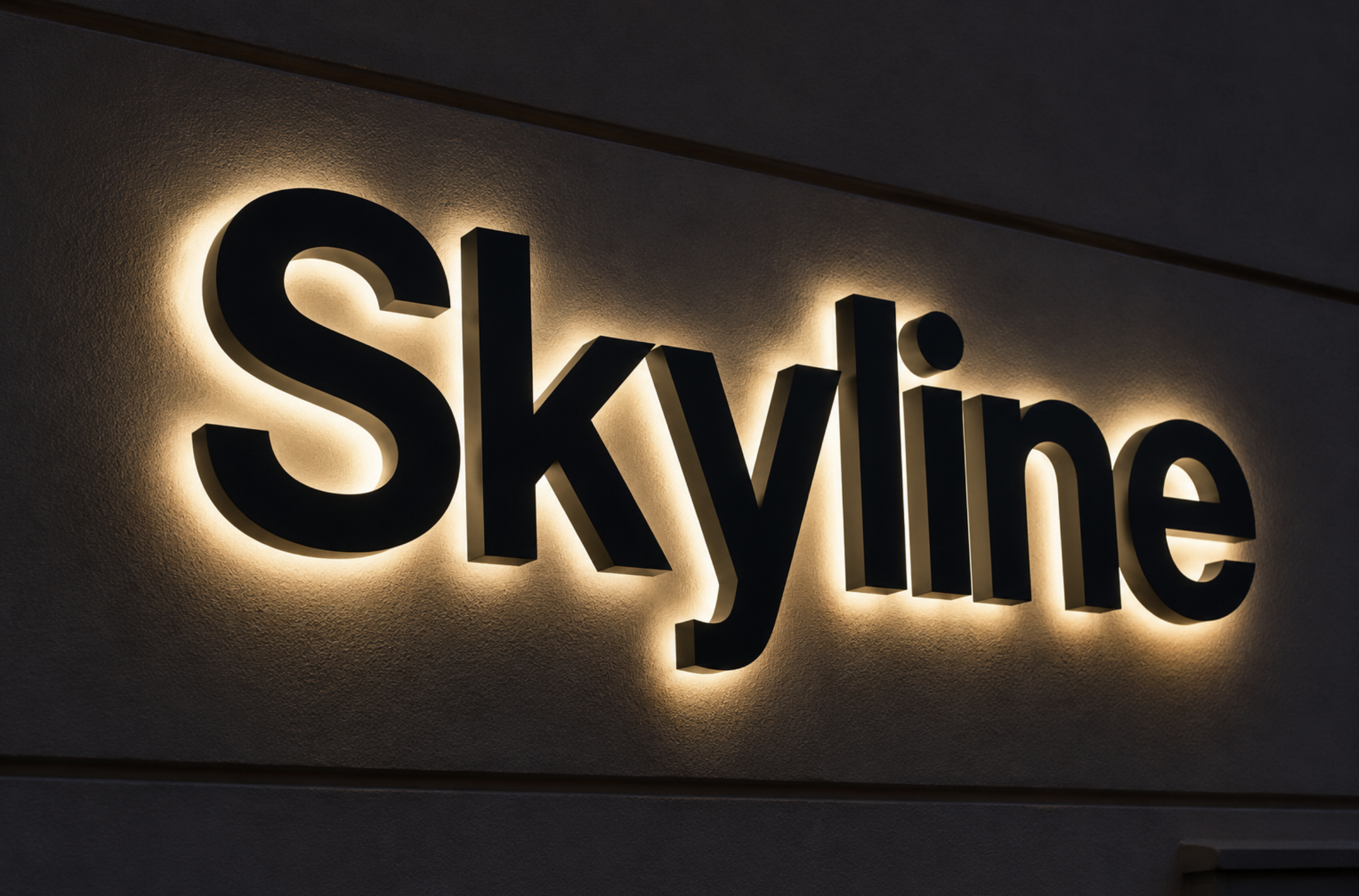 Close-up of backlit black 3D letters spelling 'Skye' on a textured wall.