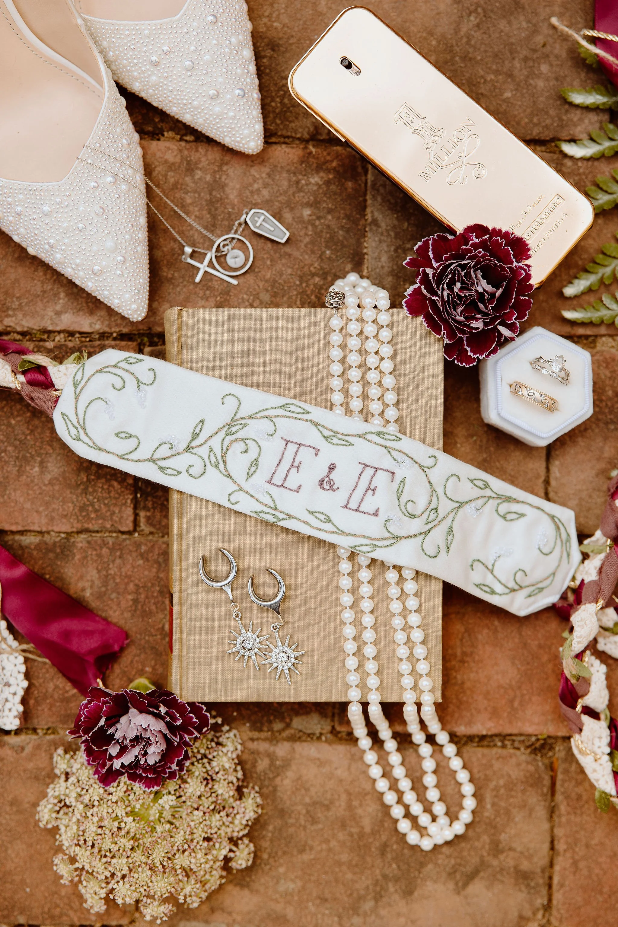 Display of vintage decor elements (handfasting cord, pearl necklace, earrings, rings, vintage book, etc.) from an event hosted at Historic Jasmine, a private wedding venue located in Greater Richmond, Virginia.