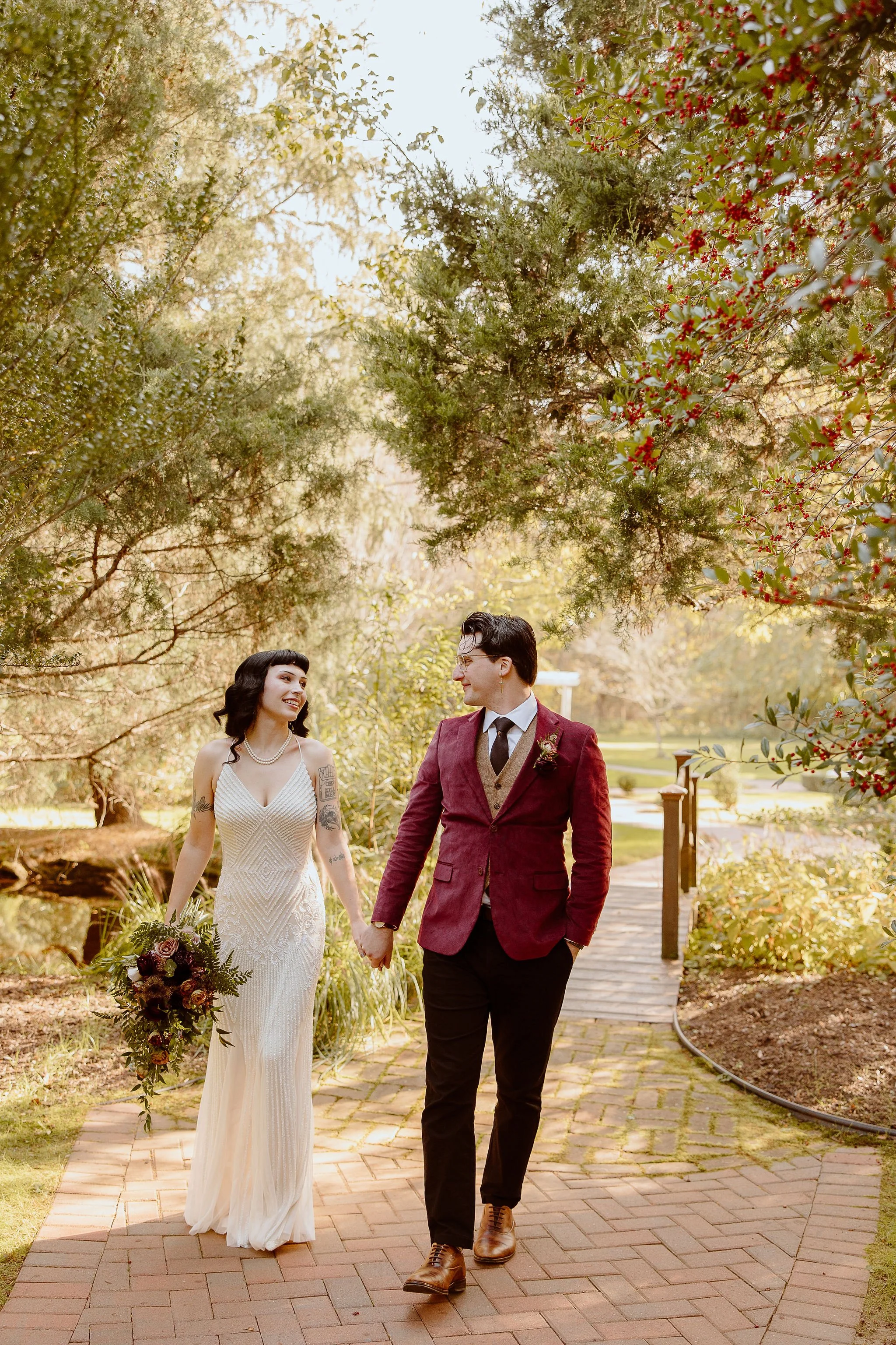A bride and groom walk through the secret garden at Historic Jasmine, a private wedding venue in Greater Richmond, Virginia.