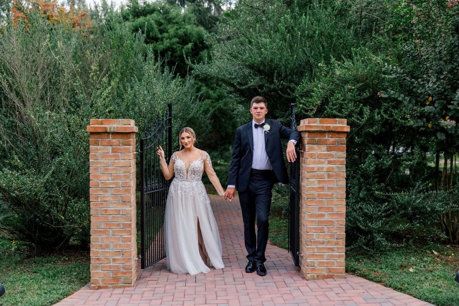 A bride and groom pose for portrait at the entrance of the secret garden at Historic Jasmine, a wedding venue full of garden whimsy located near Richmond, Virginia.