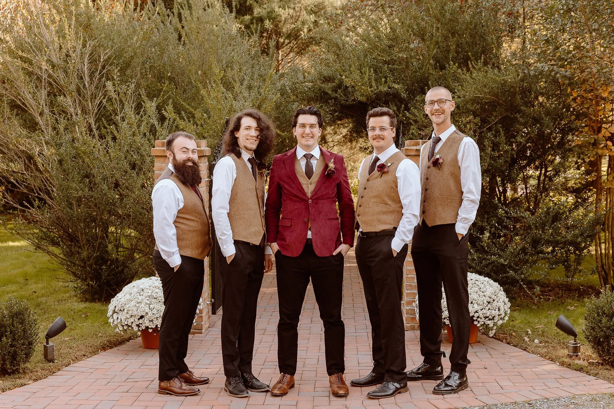 A groom and his groomsmen posing in front of the secret garden entrance at Historic Jasmine, a private wedding venue in New Kent, VA.