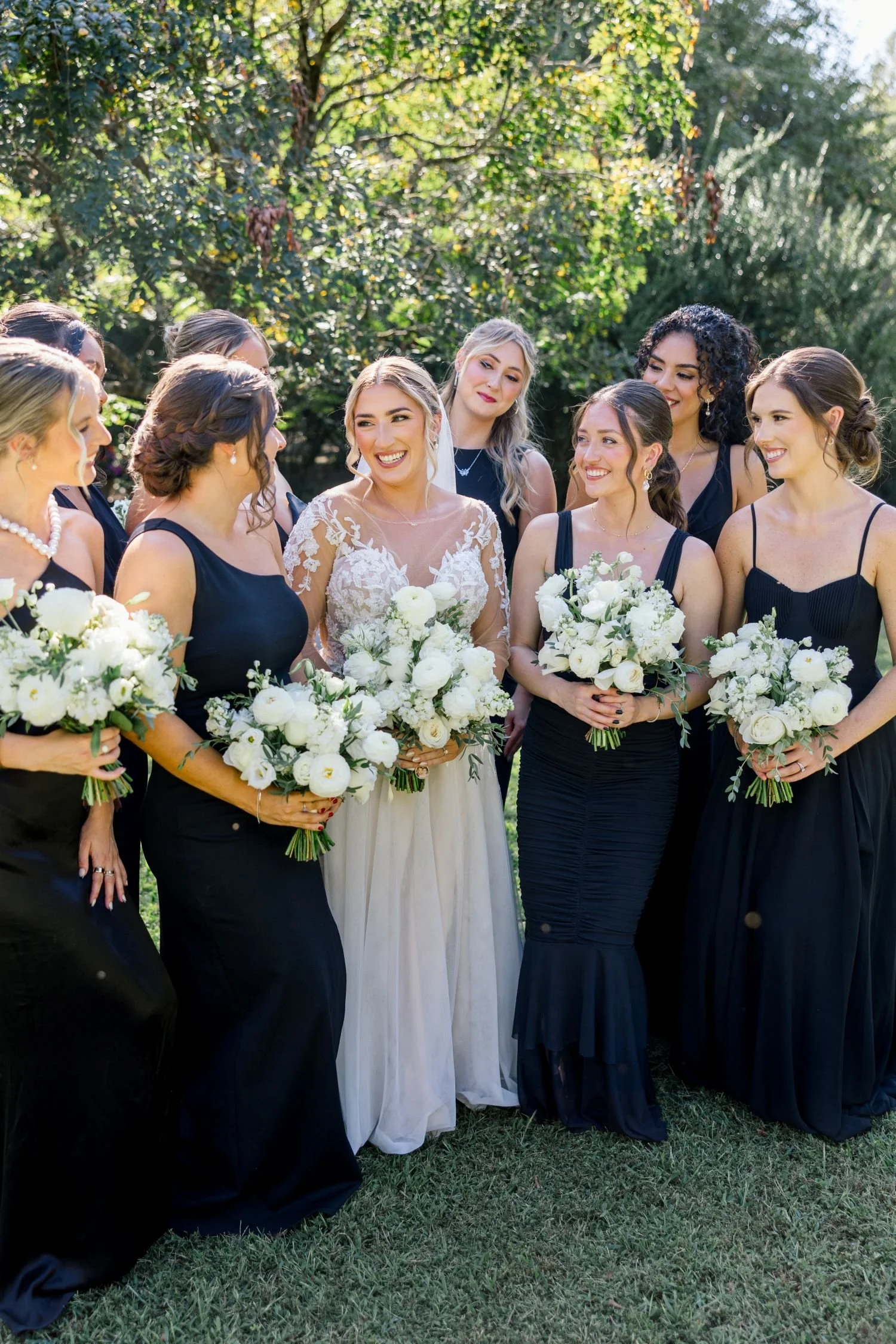 A bride and bridesmaids pose for a portrait in the private garden at Historic Jasmine, a romantic wedding venue located near Richmond, Virginia.