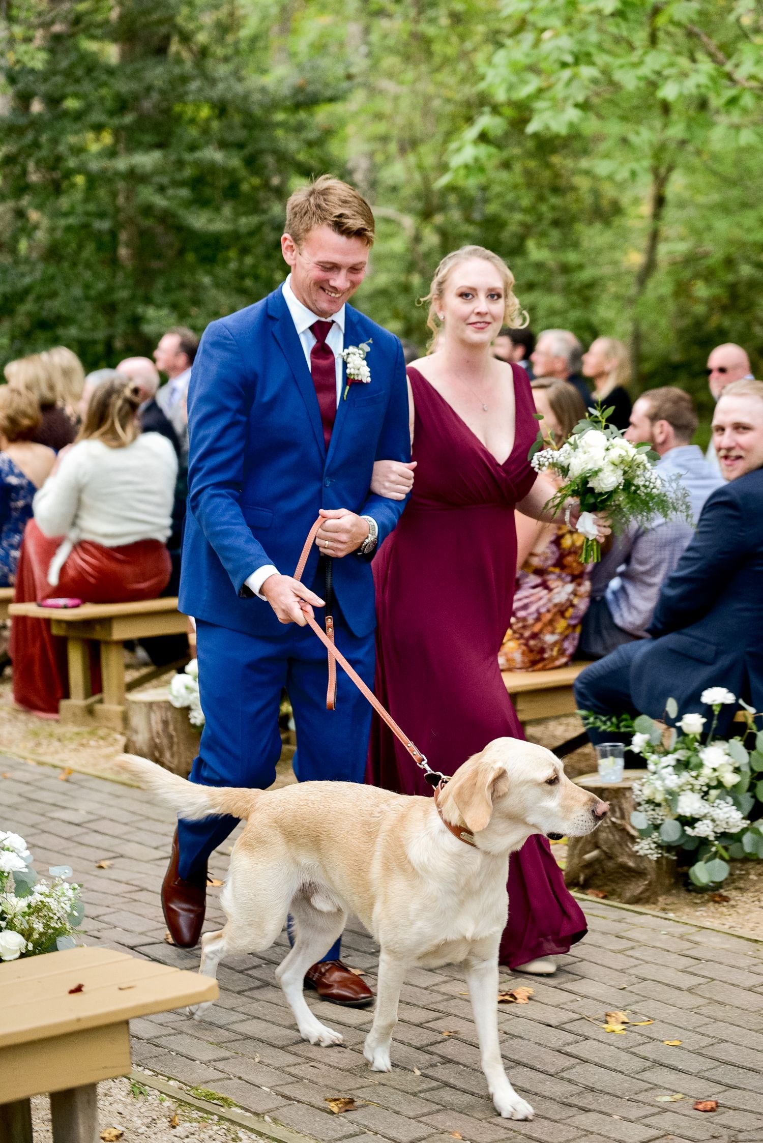 Members of the wedding party walk down the aisle with a bride's yellow lab in this pet-friendly wedding hosted at Historic Jasmine, a elegant wedding venue located near Richmond, VA