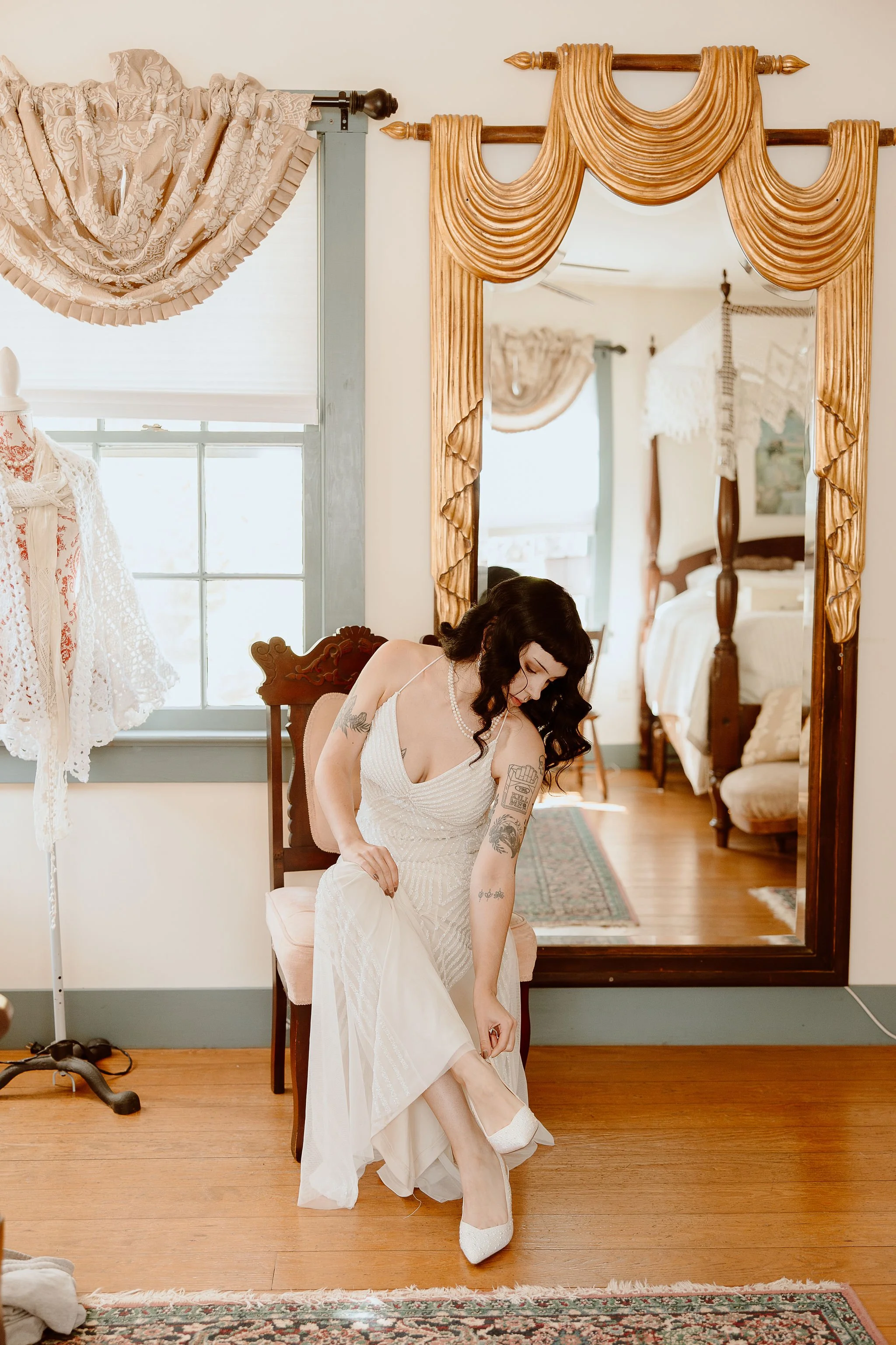 A bride getting ready in front of the mirror in bridal suite before the wedding ceremony at Historic Jasmine, a private wedding venue in Greater Richmond, Virginia.