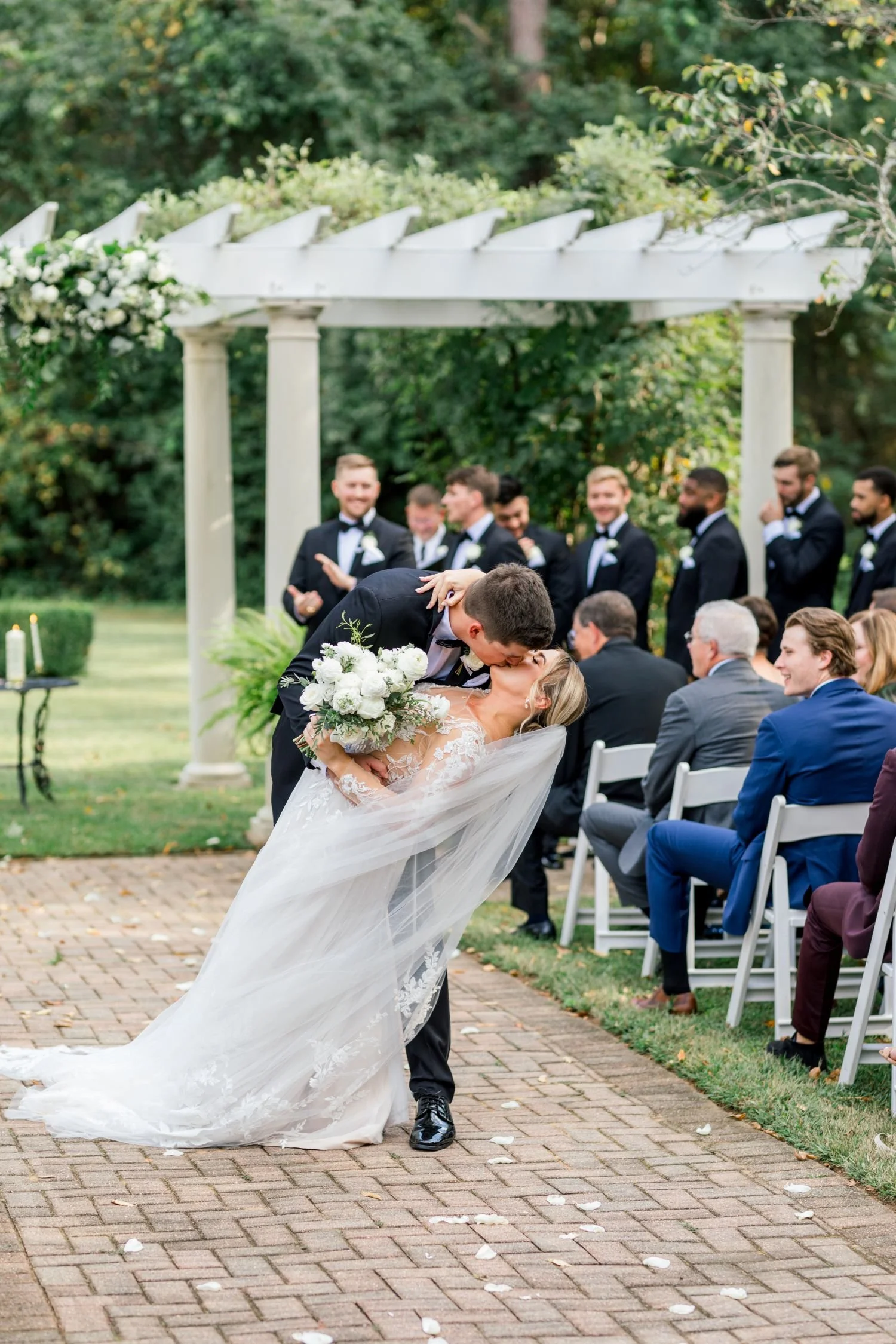A romantic moment of a newlywed couple kissing after a ceremony hosted at Historic Jasmine, a whimsical garden wedding venue in New Kent, Virginia.