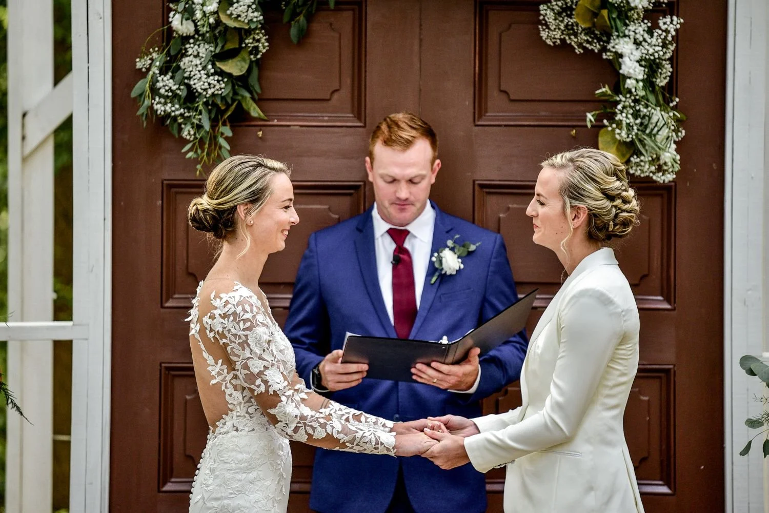 Two brides hold hands as they exchange vows at Historic Jasmine, a LGBTQ+ friendly wedding venue near Richmond, VA