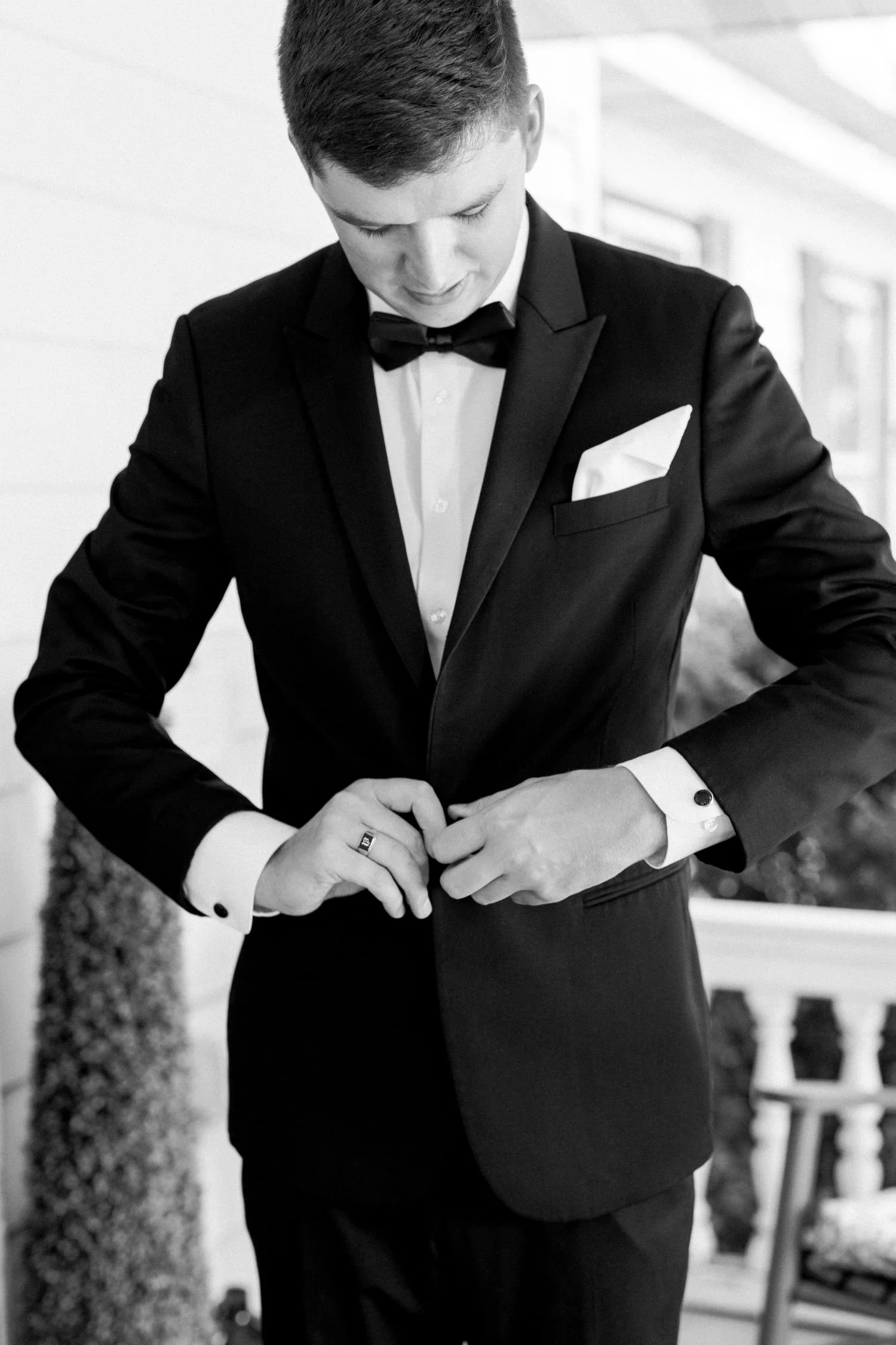A groom buttons his suit jacket before his garden wedding ceremony at Historic Jasmine, an elegant wedding venue located near Richmond, Virginia.
