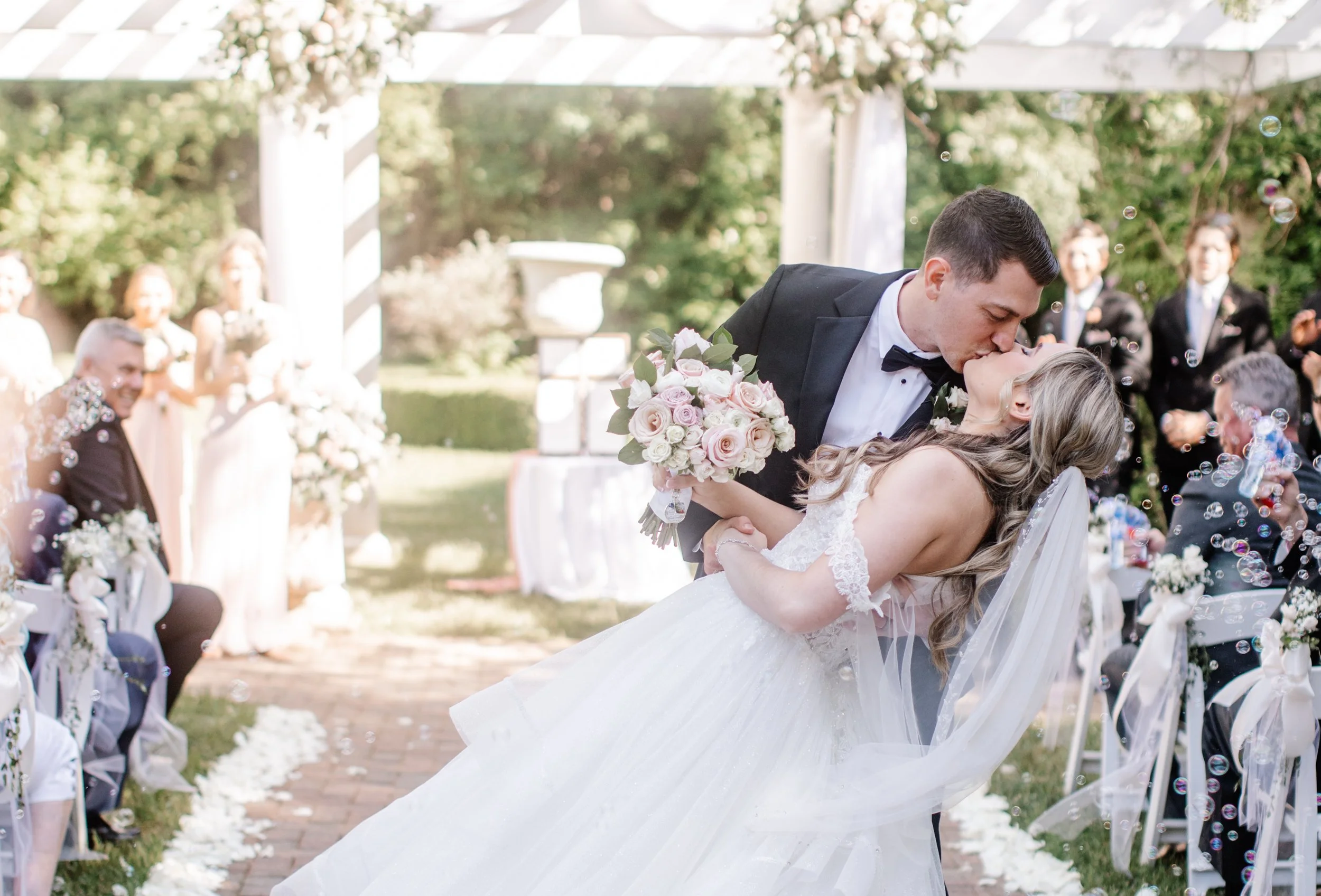 Newlyweds kiss at garden wedding ceremony