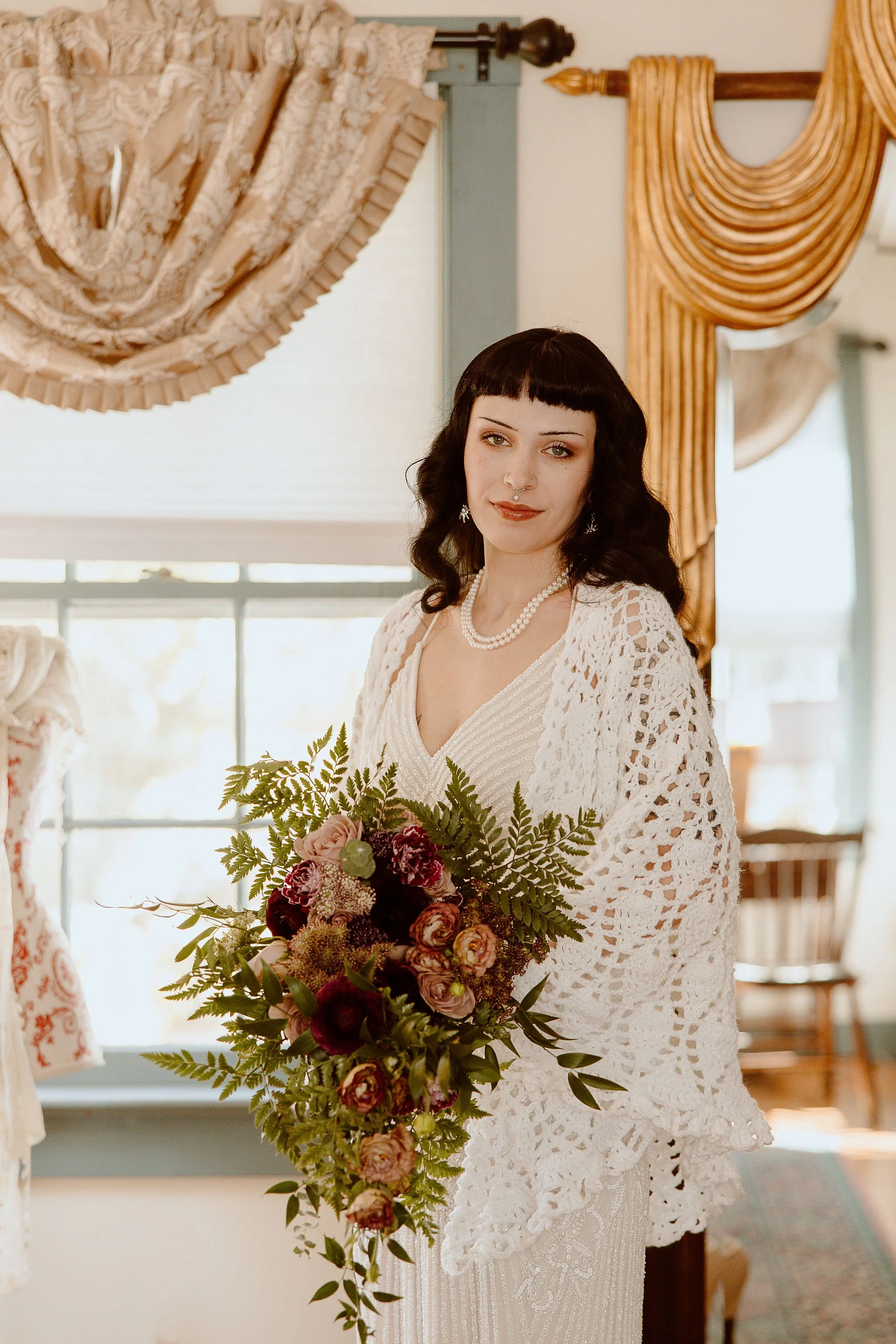 A bride poses with a bouquet in the bridal suite at Historic Jasmine.