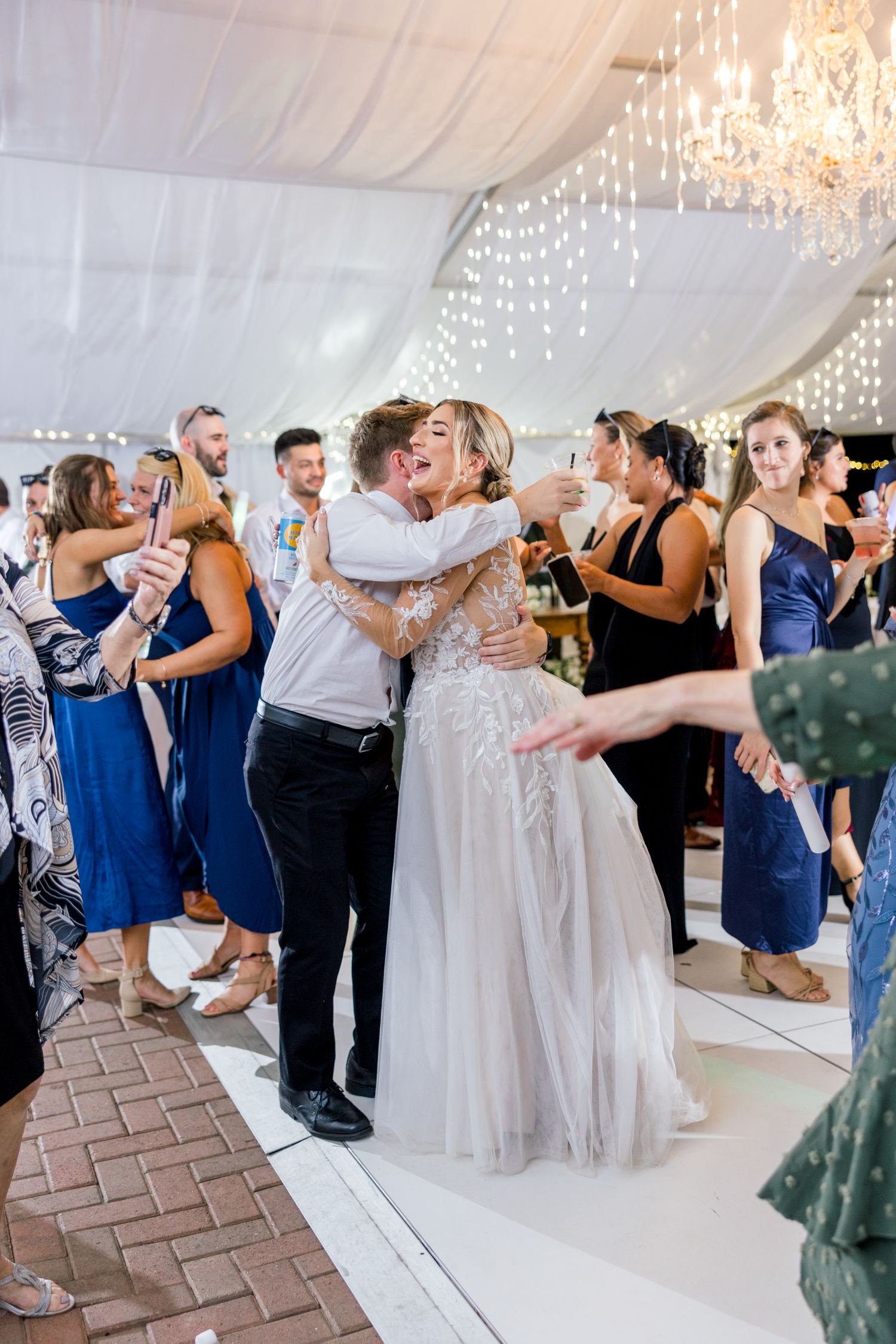 A bride greets a guest while dancing at a wedding reception hosted at Historic Jasmine, a garden wedding venue near Richmond, Virginia.