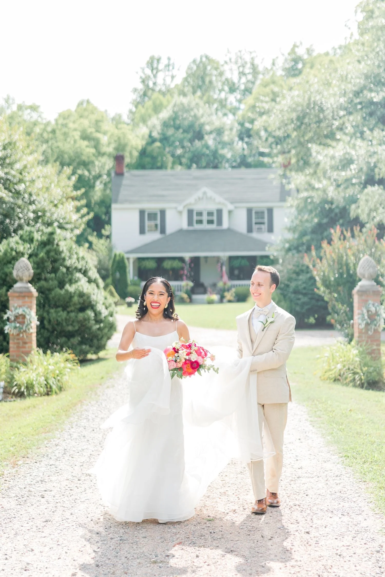A bride and groom walk down the main gravel driveway at Historic Jasmine, an estate wedding venue located near Richmond, Virginia.