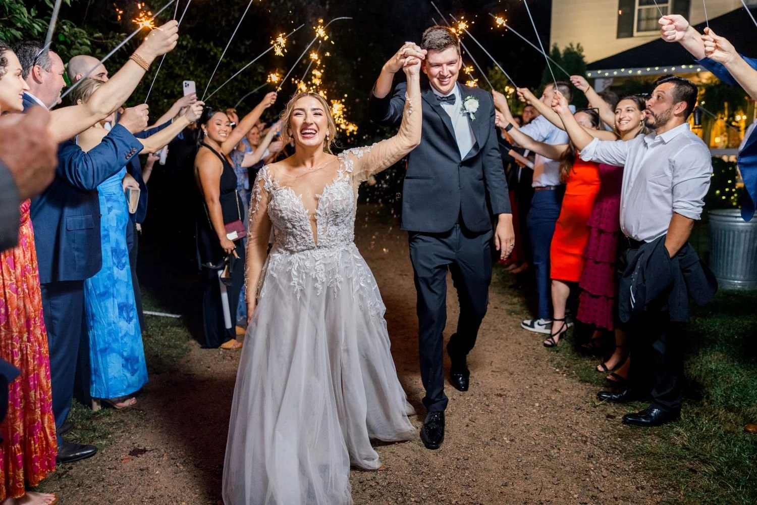A bride and groom leave a garden reception hosted at Historic Jasmine, a charming wedding venue in Providence Forge, Virginia.