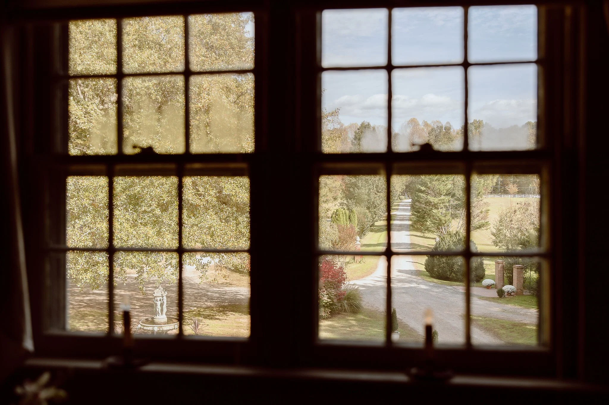 Romantic view of the gravel lane from the front windows of the Manor House located at Historic Jasmine, a private wedding venue in New Kent County, Virginia.